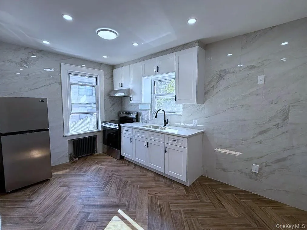 Kitchen featuring white cabinetry, stainless steel appliances, plenty of natural light, and recessed lighting Kitchen featuring white cabinetry, stainless steel appliances, plenty of natural light, and recessed lighting