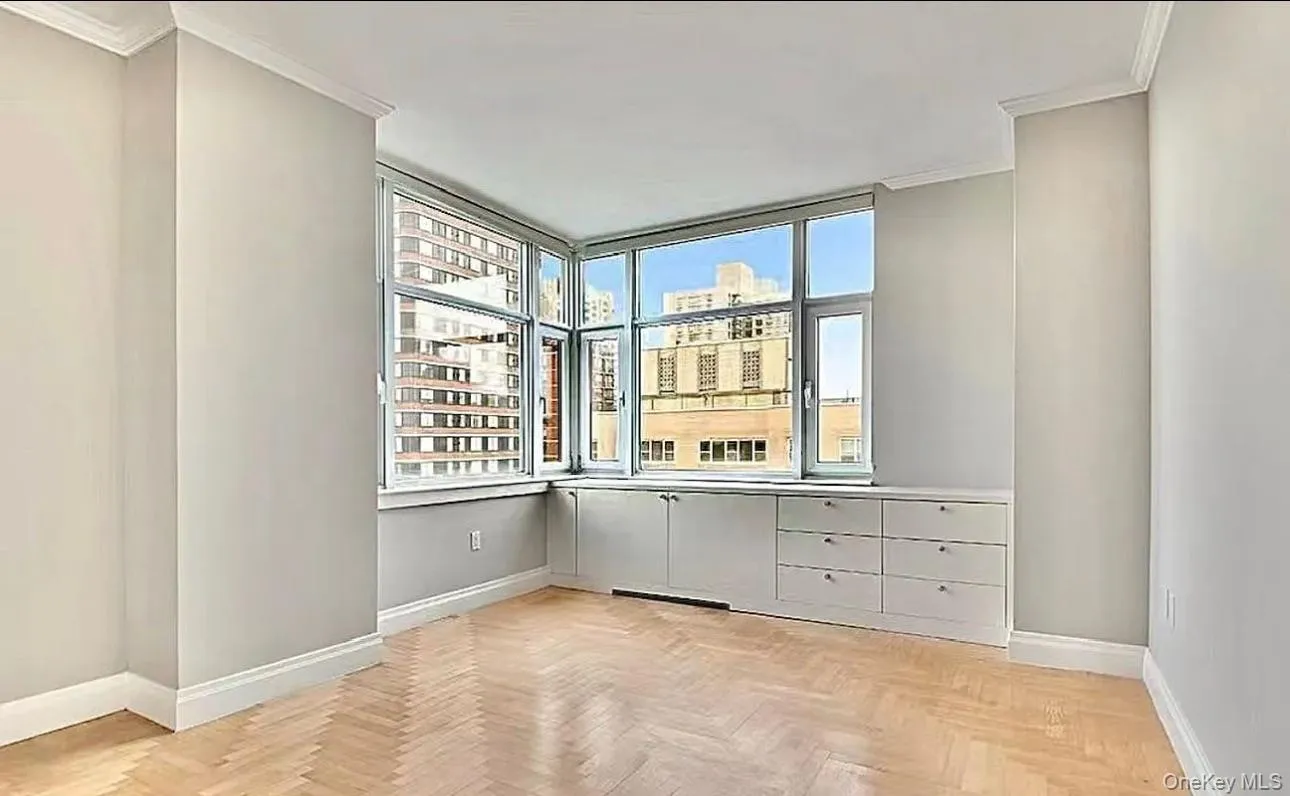 Spare room featuring a view of city, ornamental molding, and plenty of natural light Spare room featuring a view of city, ornamental molding, and plenty of natural light