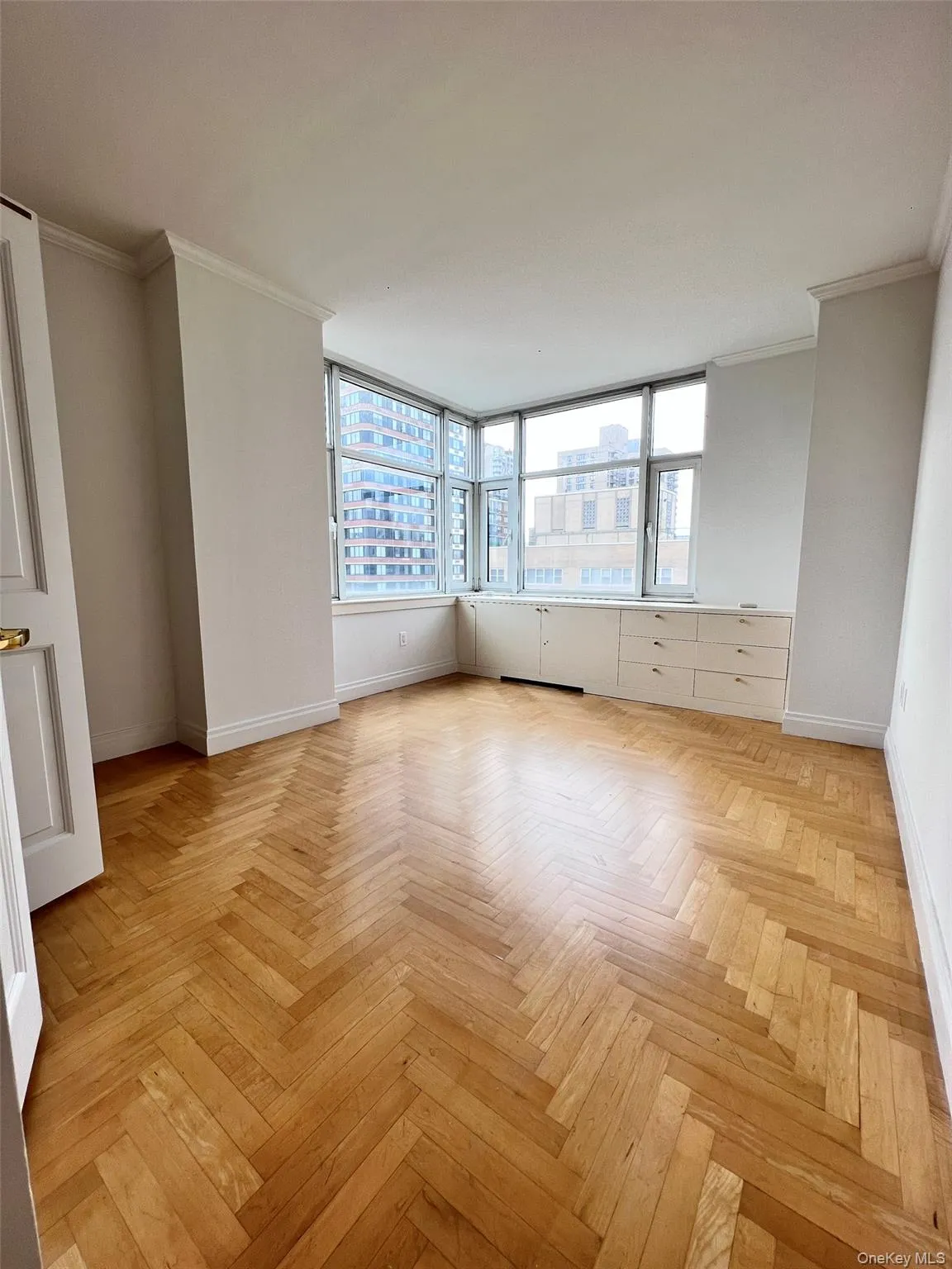 Unfurnished room featuring crown molding and a city view Unfurnished room featuring crown molding and a city view