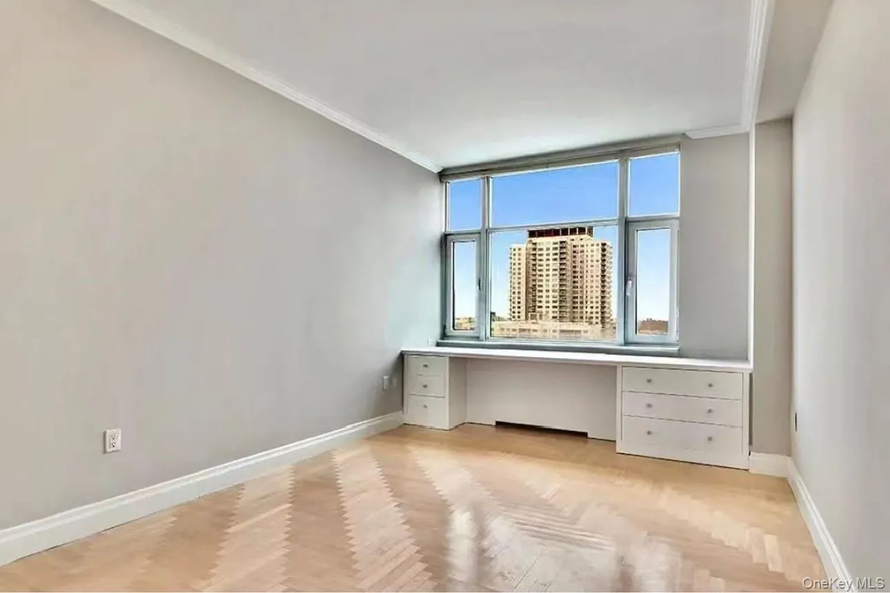 Unfurnished office featuring built in desk and crown molding Unfurnished office featuring built in desk and crown molding