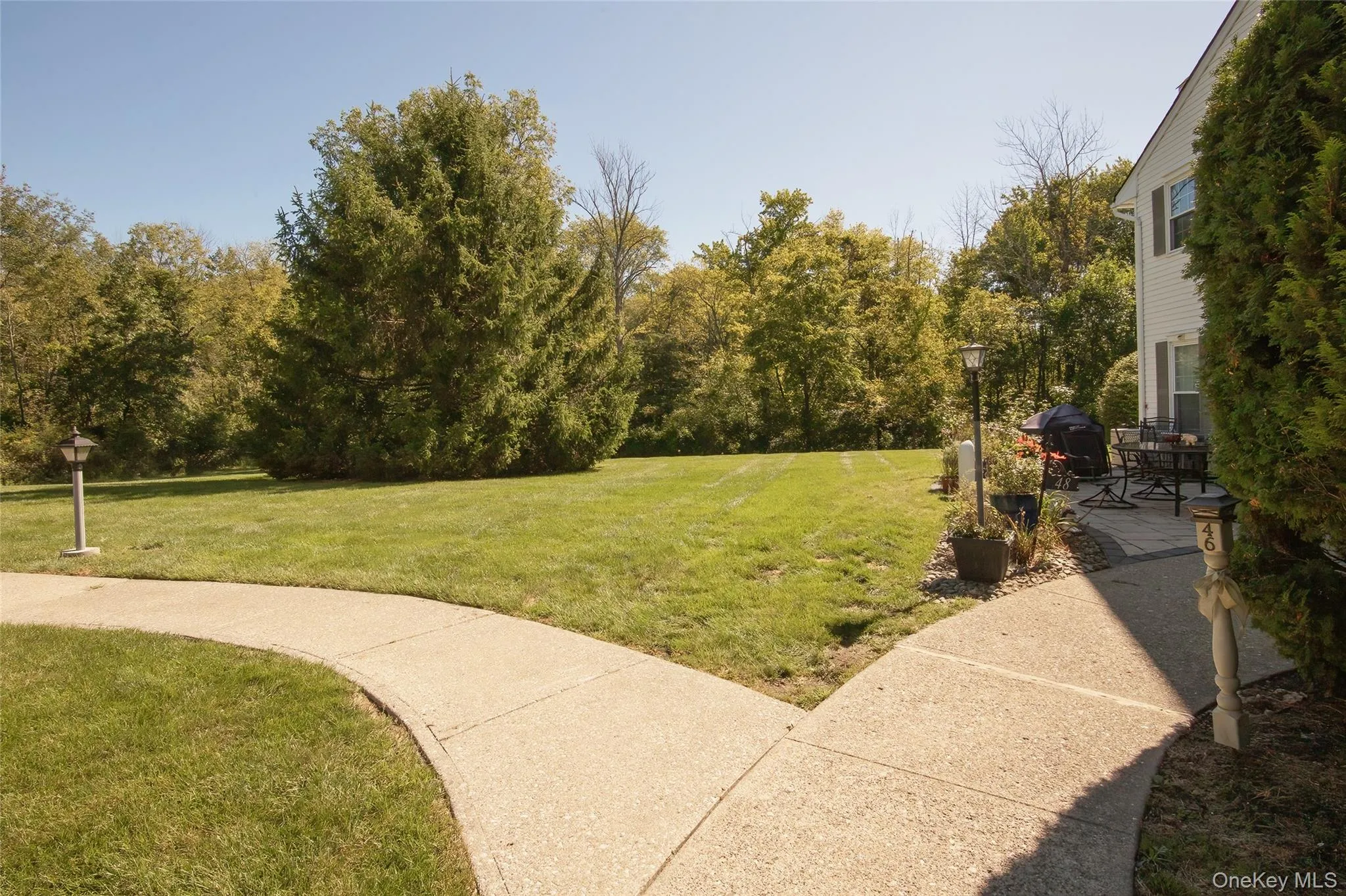 View of green lawn with a patio View of green lawn with a patio