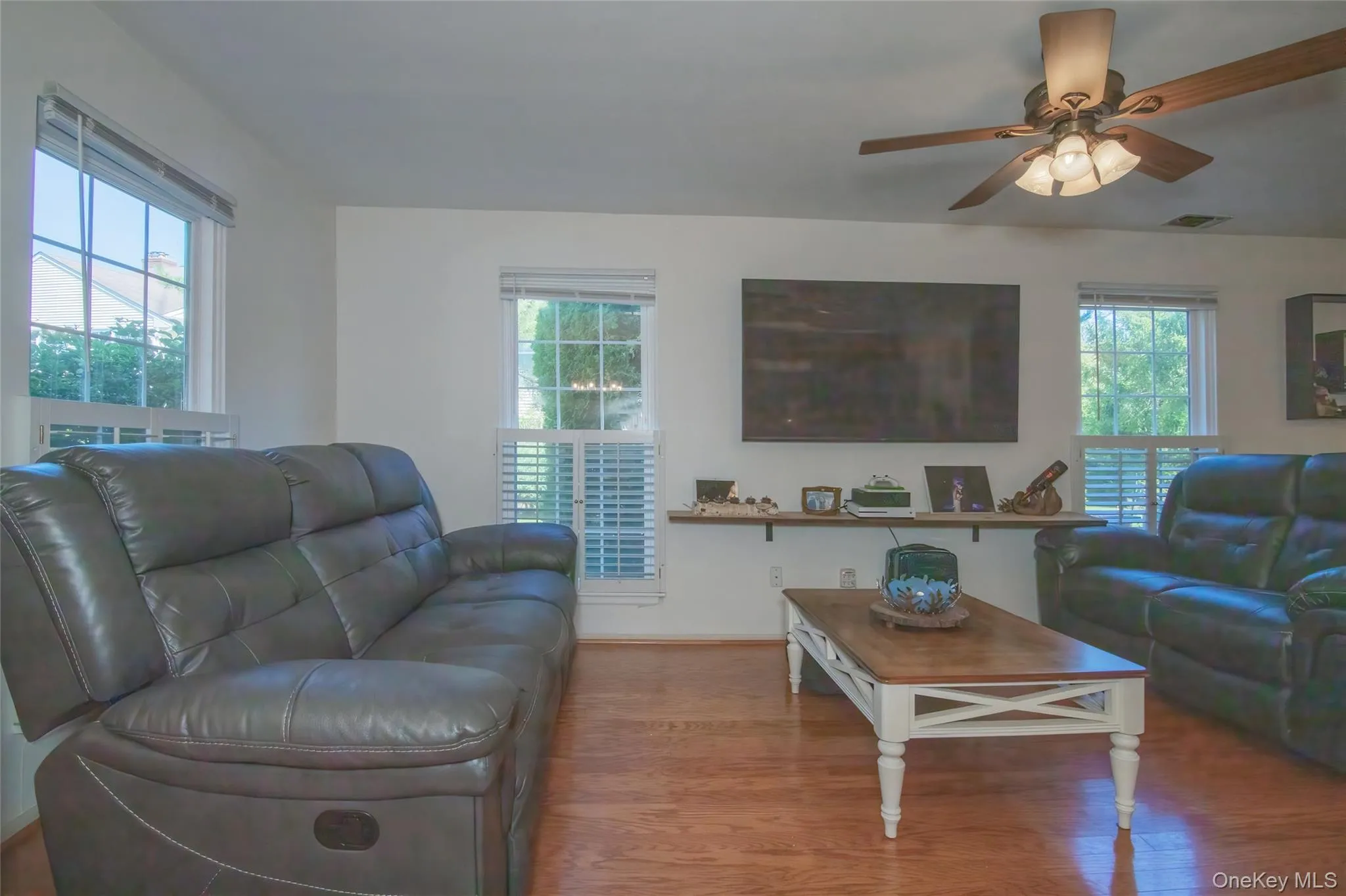 Living room with wood finished floors and a ceiling fan Living room with wood finished floors and a ceiling fan