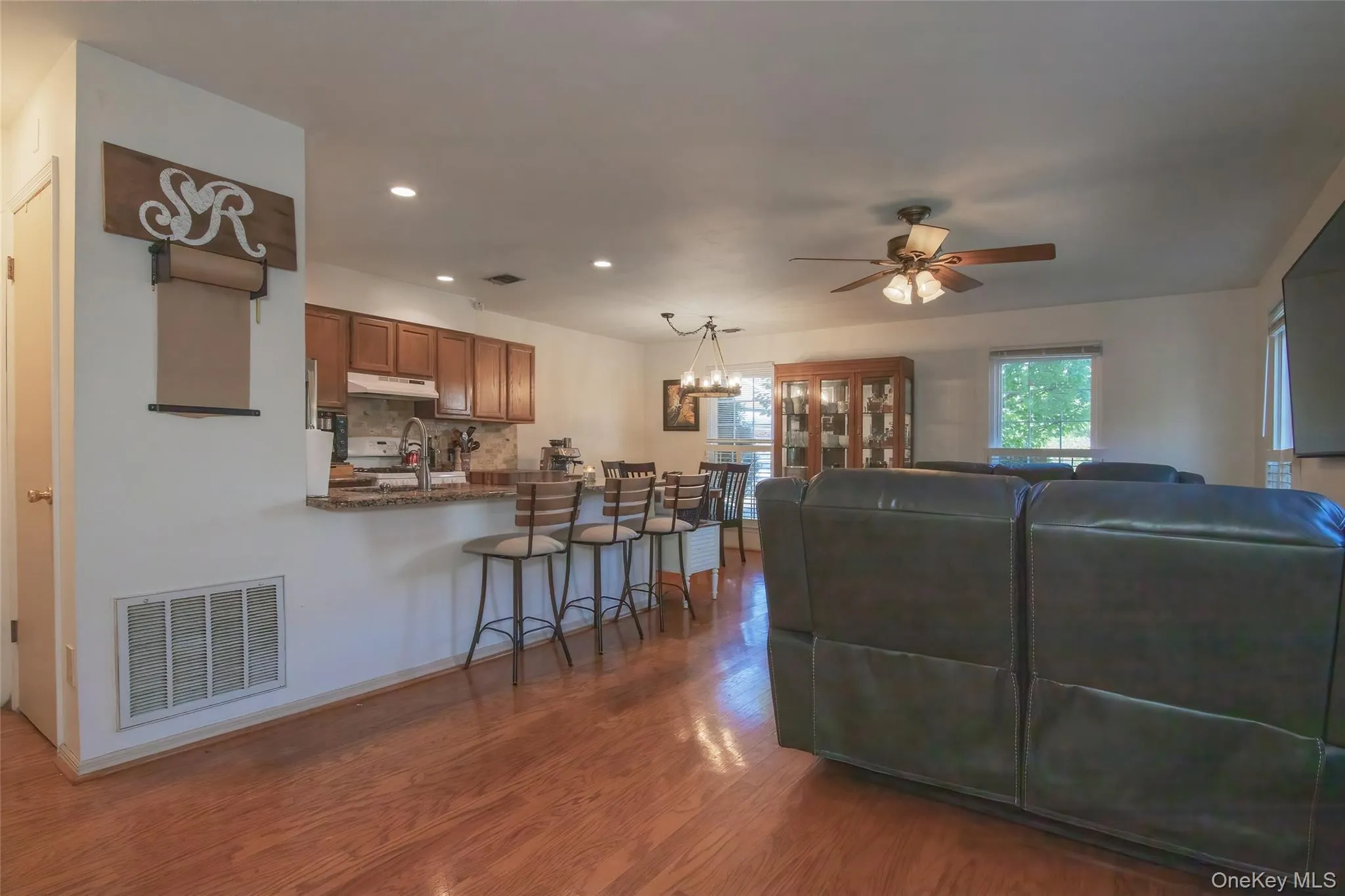 Living room featuring light wood-type flooring, recessed lighting, a chandelier, and ceiling fan Living room featuring light wood-type flooring, recessed lighting, a chandelier, and ceiling fan