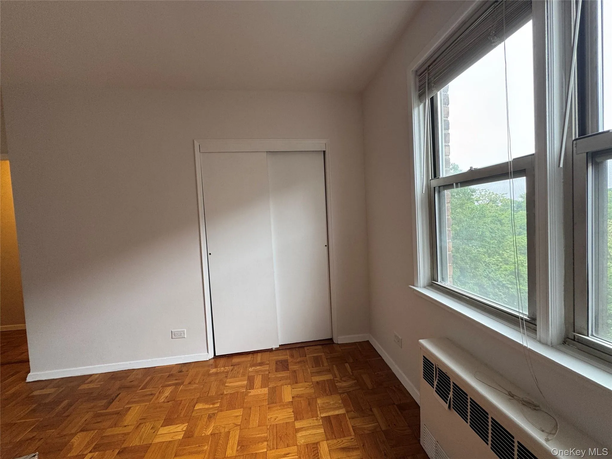 Unfurnished bedroom with radiator and a closet Unfurnished bedroom with radiator and a closet