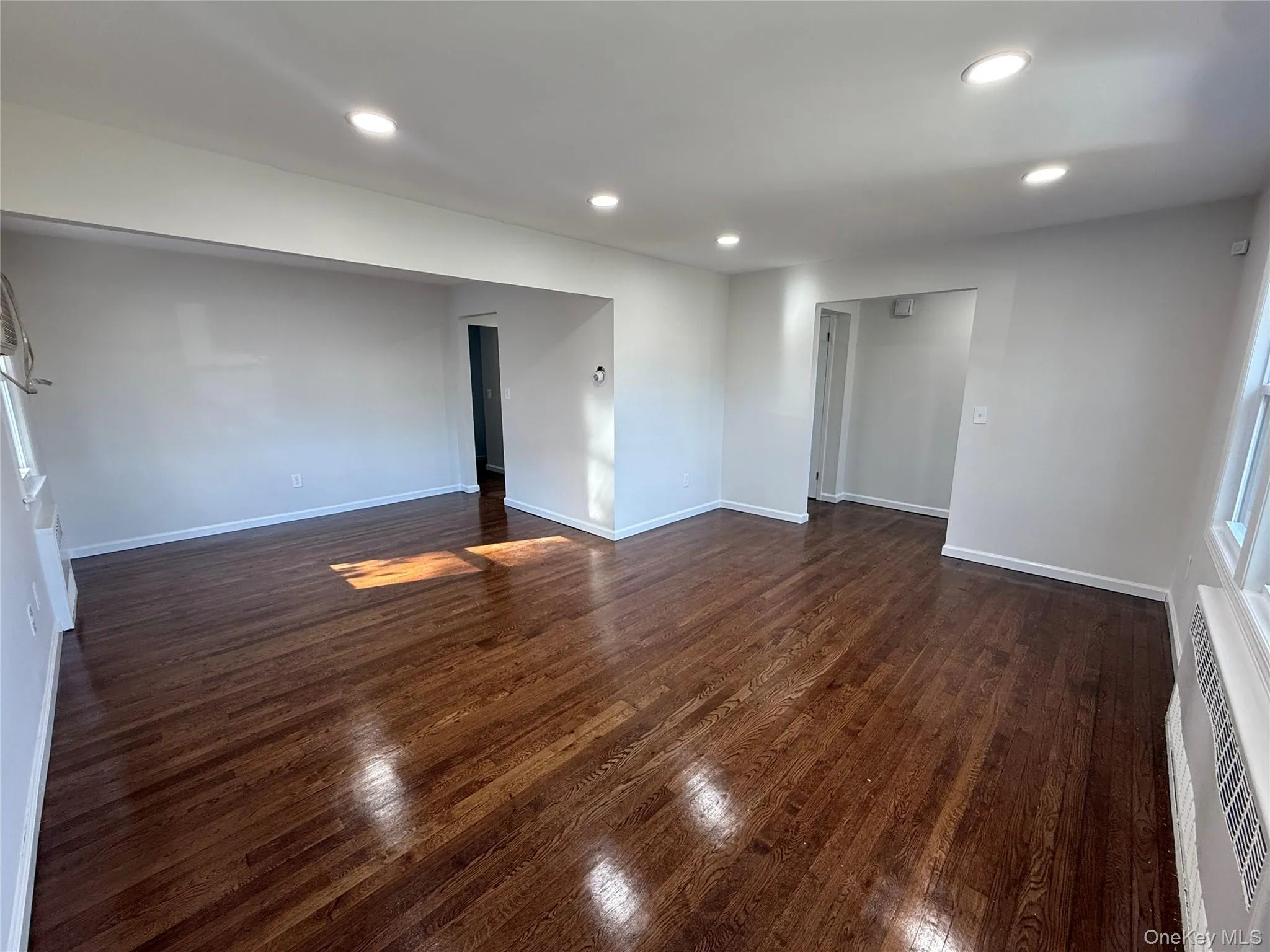 Empty room featuring recessed lighting and dark wood-style flooring Empty room featuring recessed lighting and dark wood-style flooring