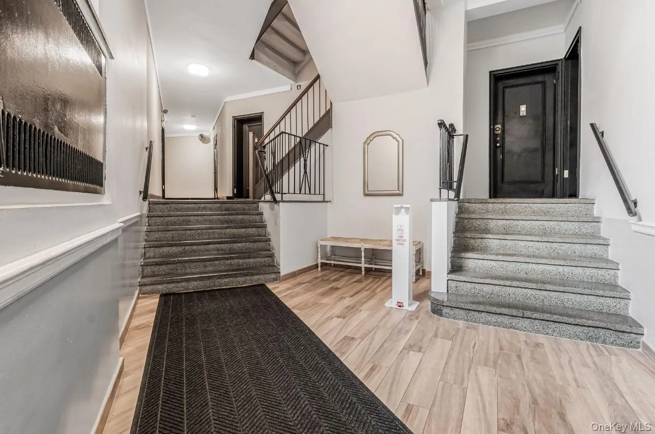 Stairway featuring ornamental molding and wood finished floors Stairway featuring ornamental molding and wood finished floors