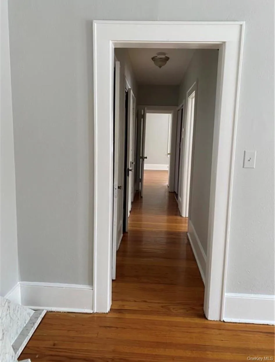 Hall featuring dark wood-type flooring Hall featuring dark wood-type flooring