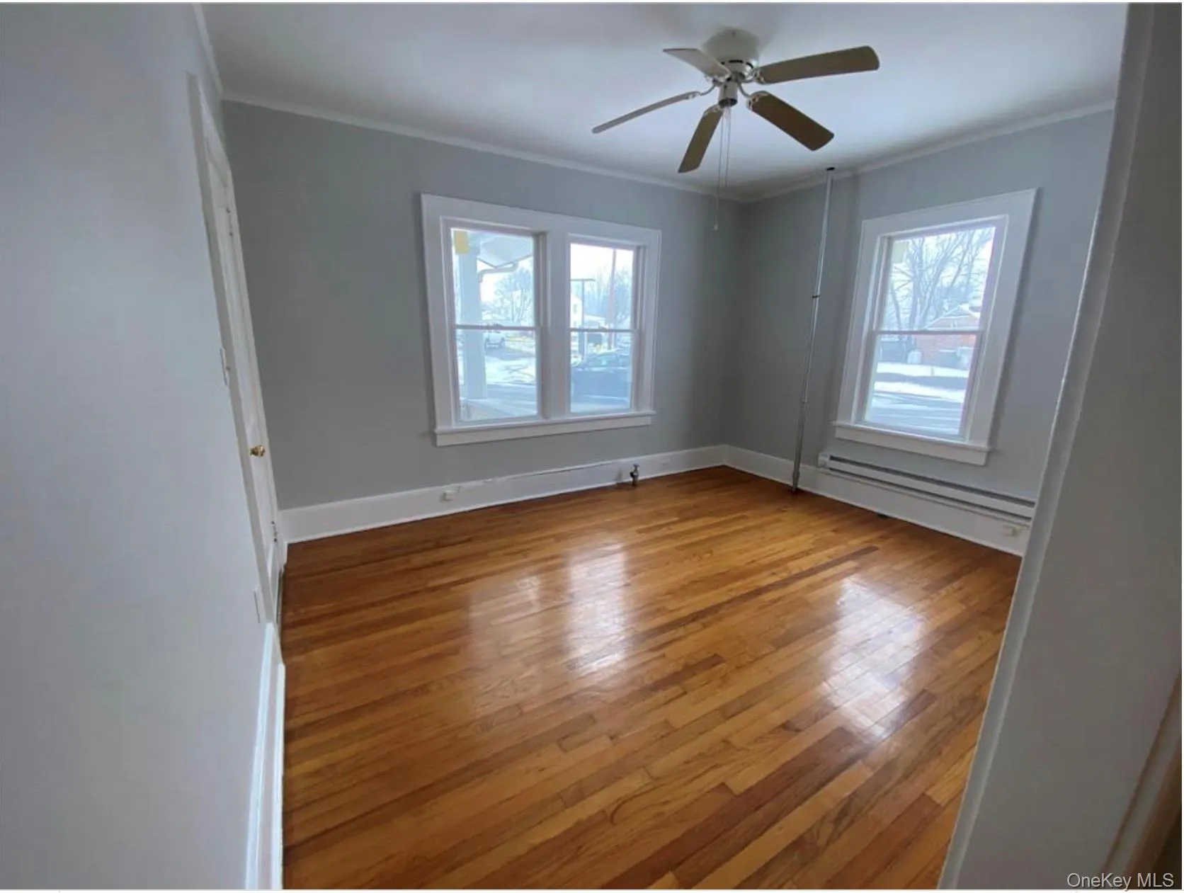 Spare room with crown molding, light wood-style floors, a baseboard radiator, and a ceiling fan Spare room with crown molding, light wood-style floors, a baseboard radiator, and a ceiling fan