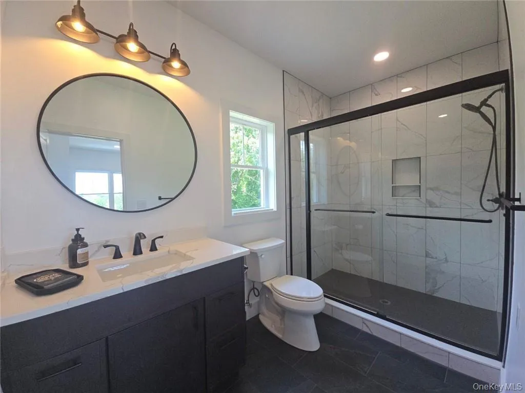 Bathroom with vanity, a stall shower, and recessed lighting Bathroom with vanity, a stall shower, and recessed lighting