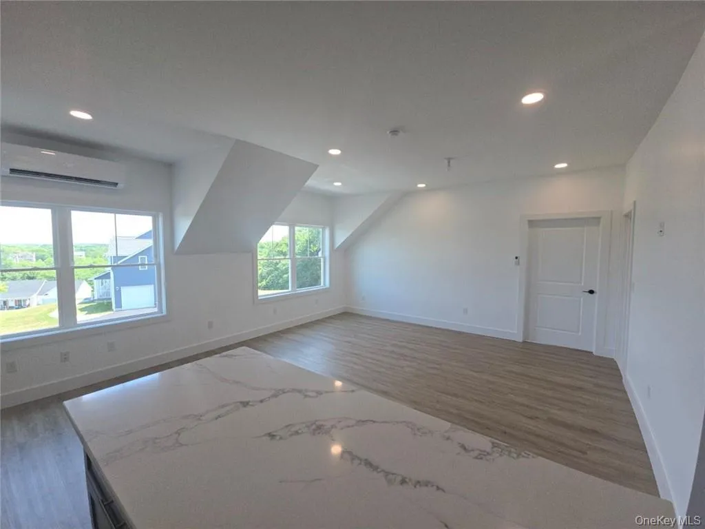 Bonus room featuring recessed lighting, wood finished floors, and a wall mounted AC Bonus room featuring recessed lighting, wood finished floors, and a wall mounted AC