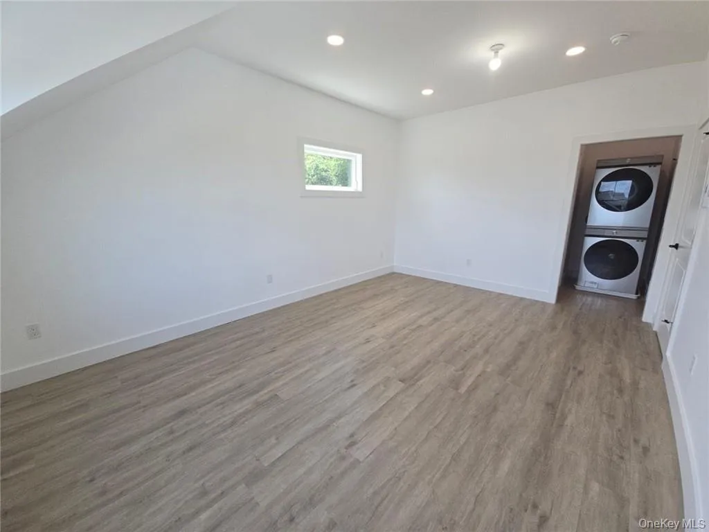 Spare room featuring light wood-type flooring, recessed lighting, and stacked washer / drying machine Spare room featuring light wood-type flooring, recessed lighting, and stacked washer / drying machine