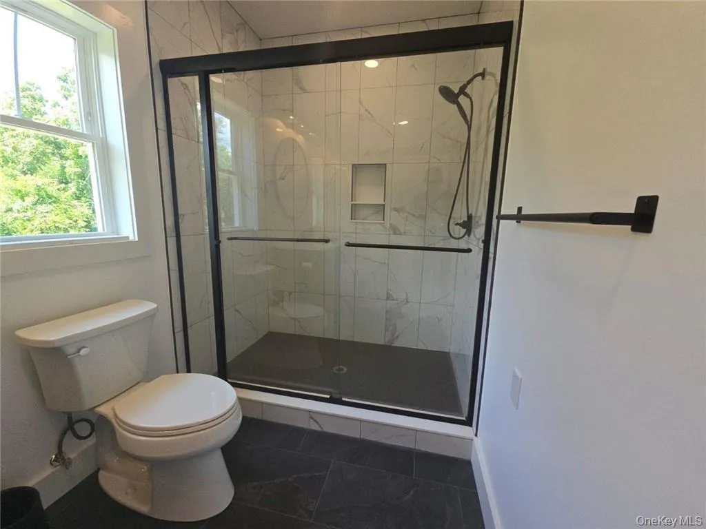 Bathroom featuring toilet and a stall shower Bathroom featuring toilet and a stall shower