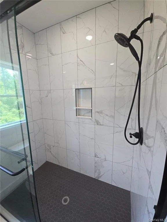 Bathroom featuring a marble finish shower Bathroom featuring a marble finish shower