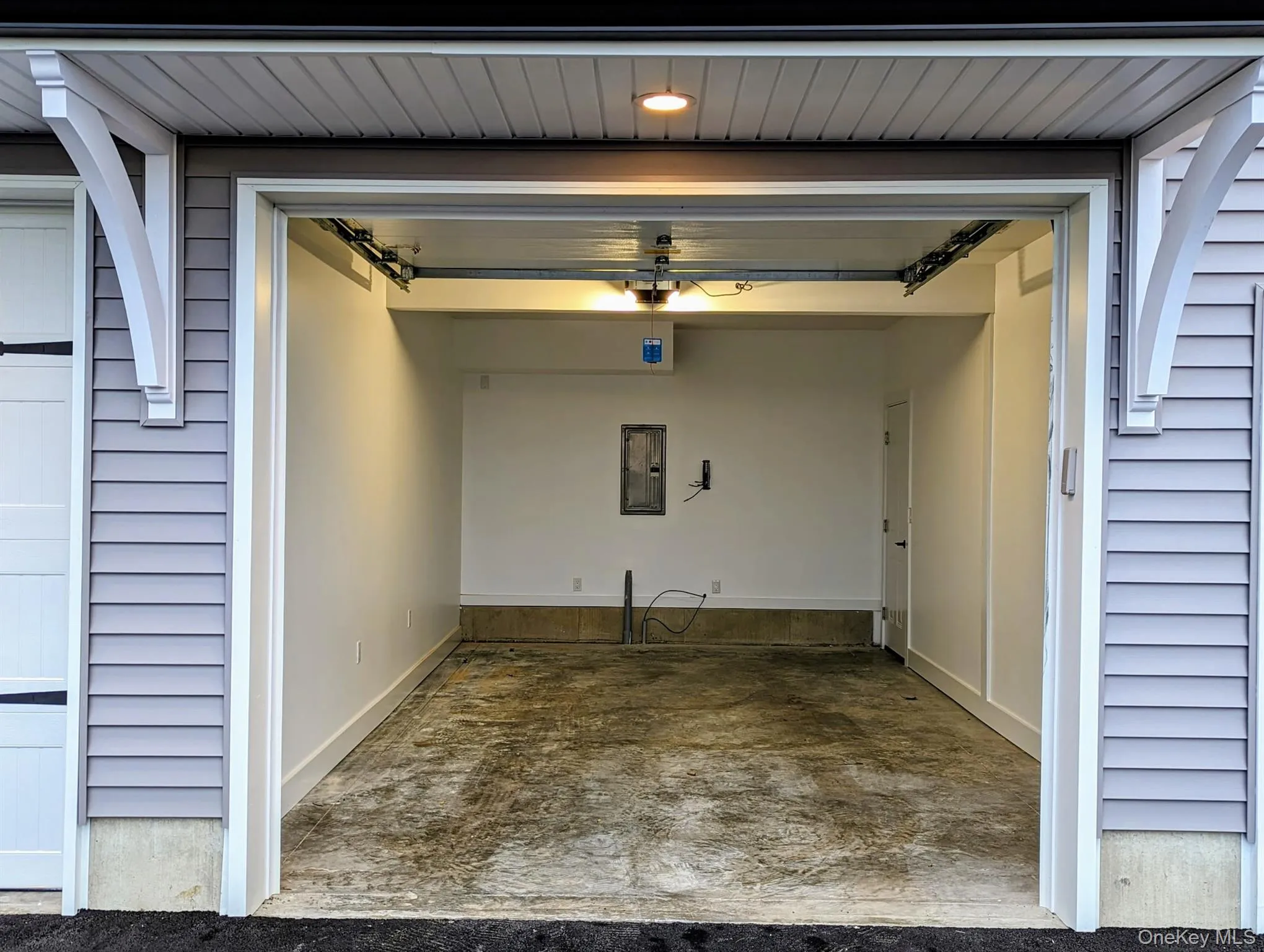 Garage with baseboards and electric panel Garage with baseboards and electric panel