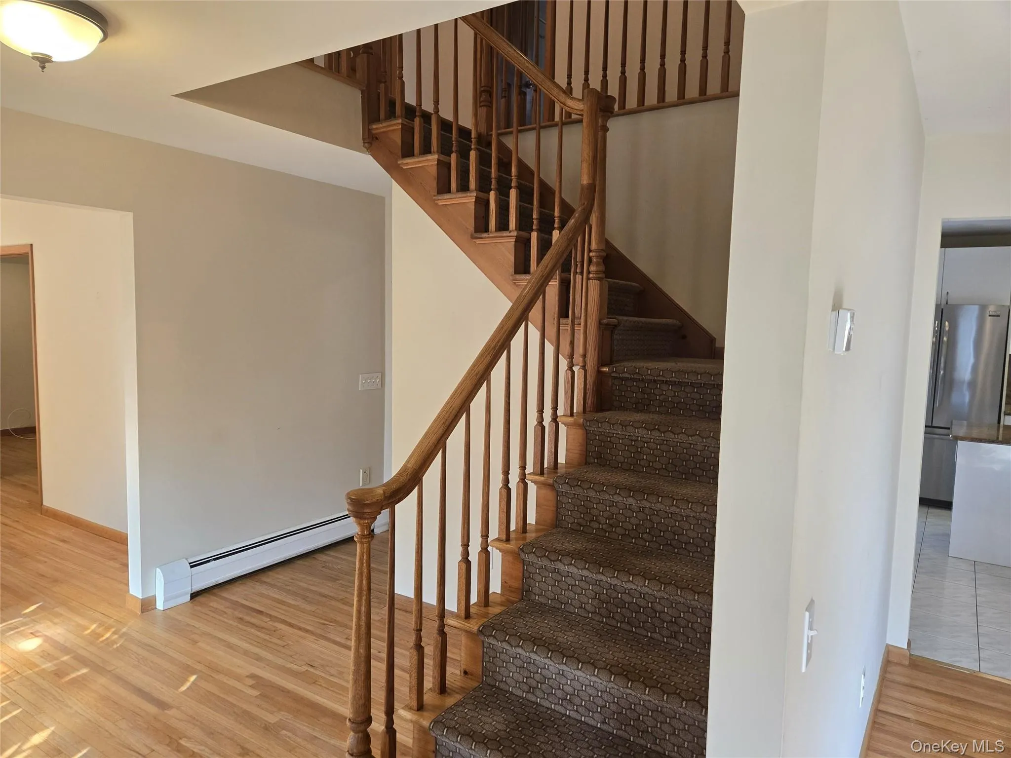 Stairway with a baseboard radiator and wood finished floors Stairway with a baseboard radiator and wood finished floors