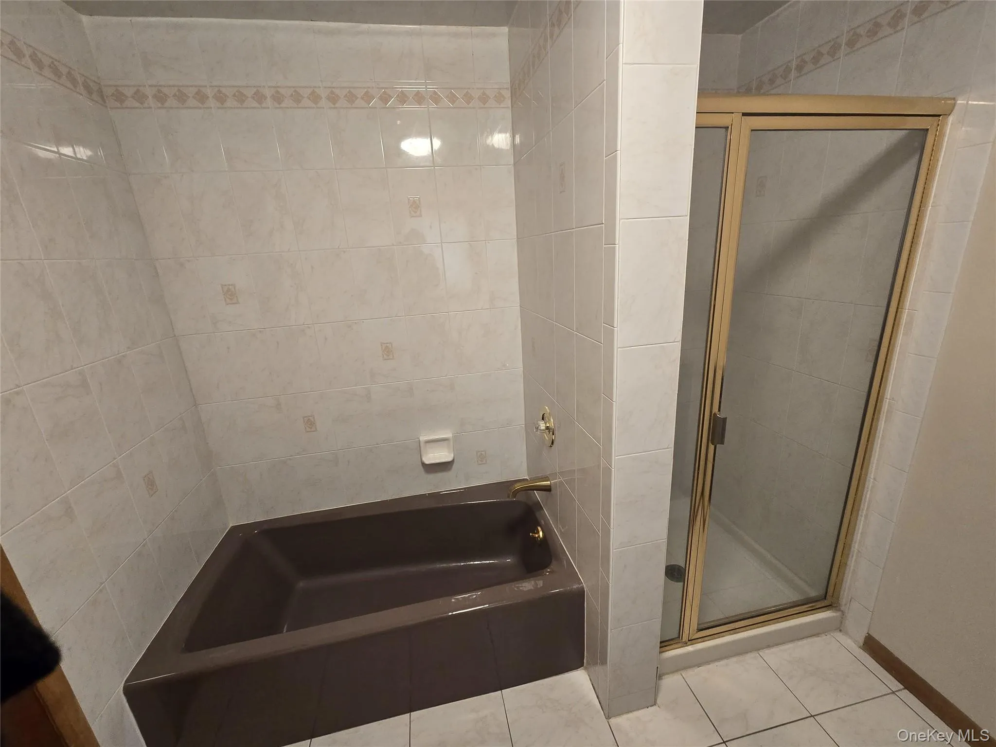 Bathroom with a garden tub, a stall shower, and tile patterned floors Bathroom with a garden tub, a stall shower, and tile patterned floors