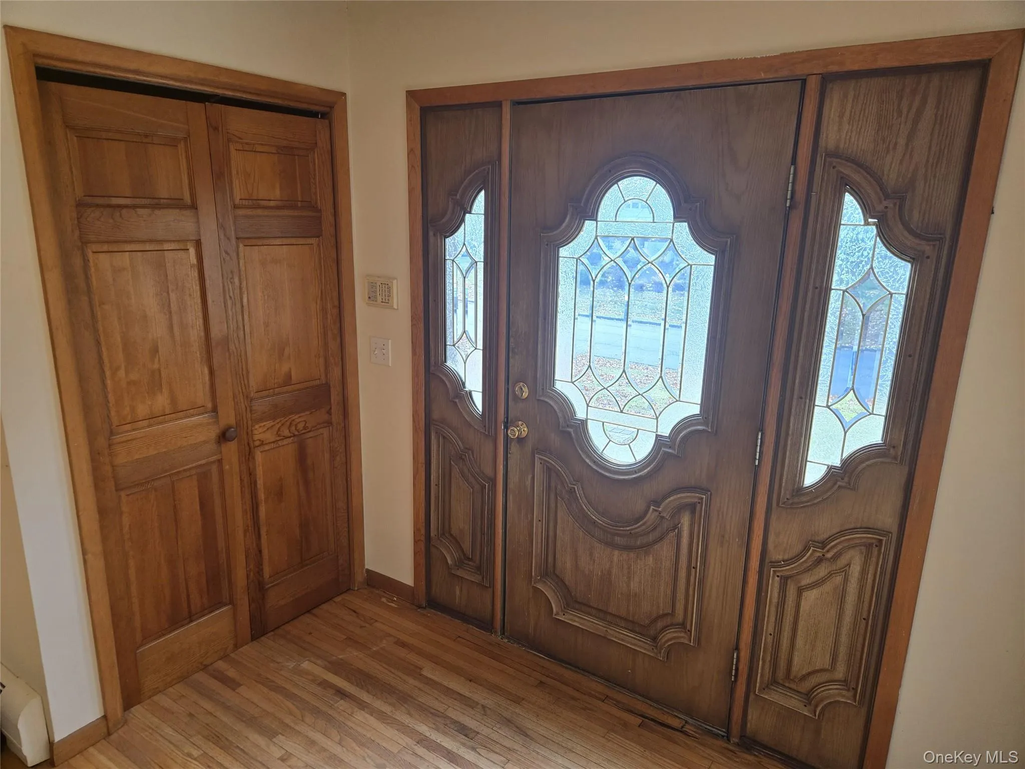 Foyer entrance with hardwood / wood-style flooring and baseboards Foyer entrance with hardwood / wood-style flooring and baseboards