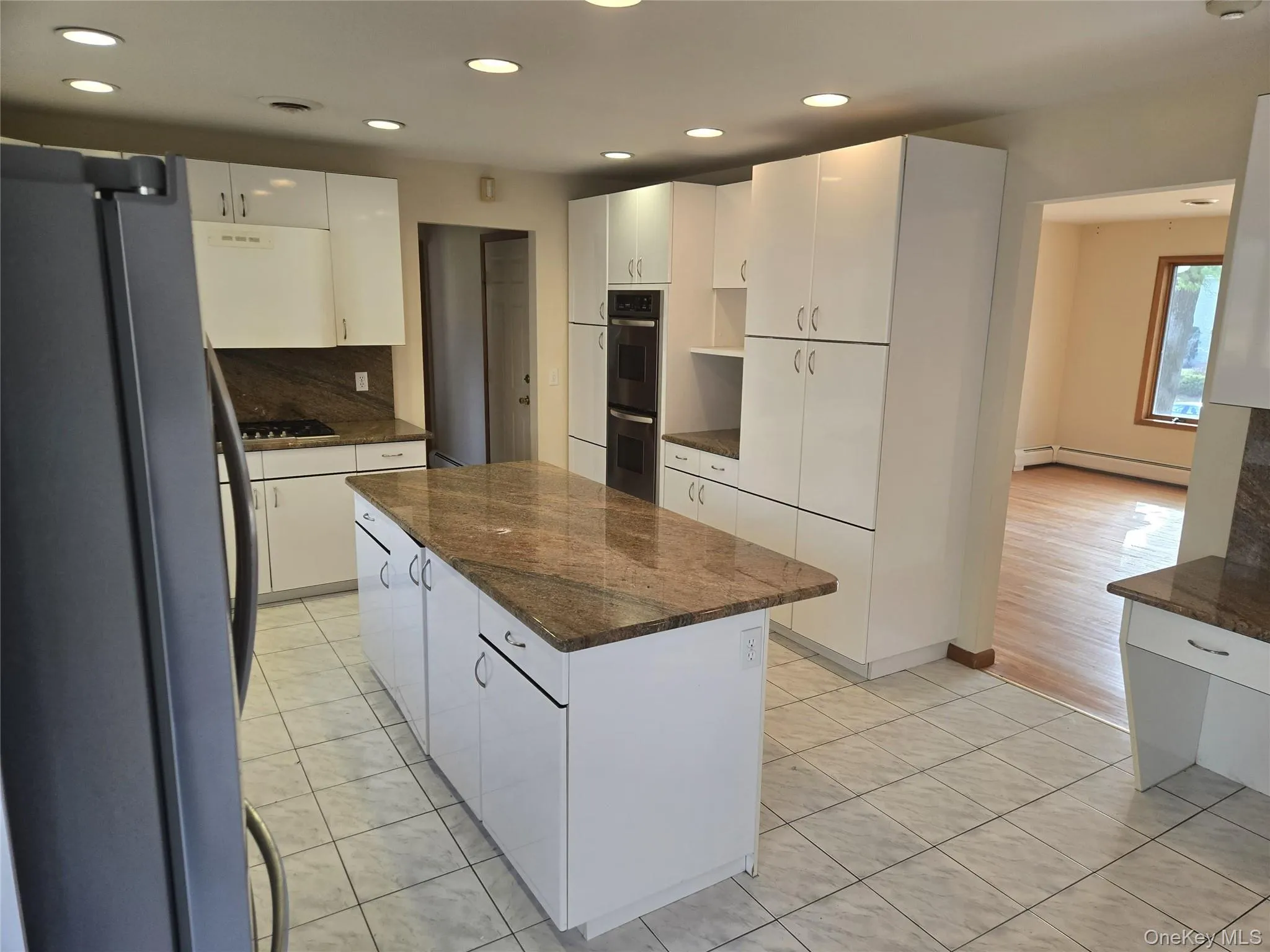 Kitchen featuring stainless steel appliances, light tile patterned flooring, white cabinets, recessed lighting, and decorative backsplash Kitchen featuring stainless steel appliances, light tile patterned flooring, white cabinets, recessed lighting, and decorative backsplash