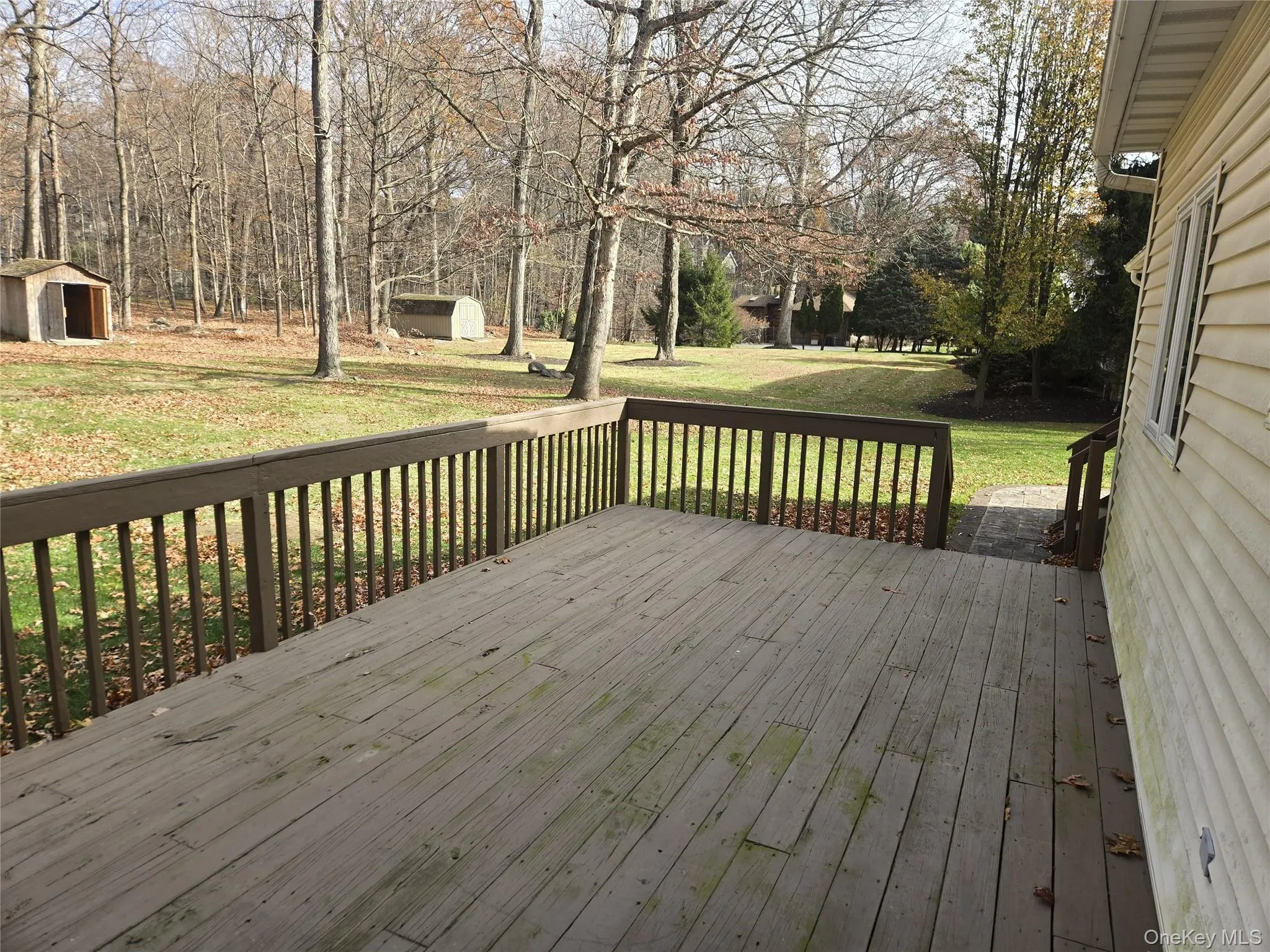 Wooden deck featuring a lawn and a shed Wooden deck featuring a lawn and a shed