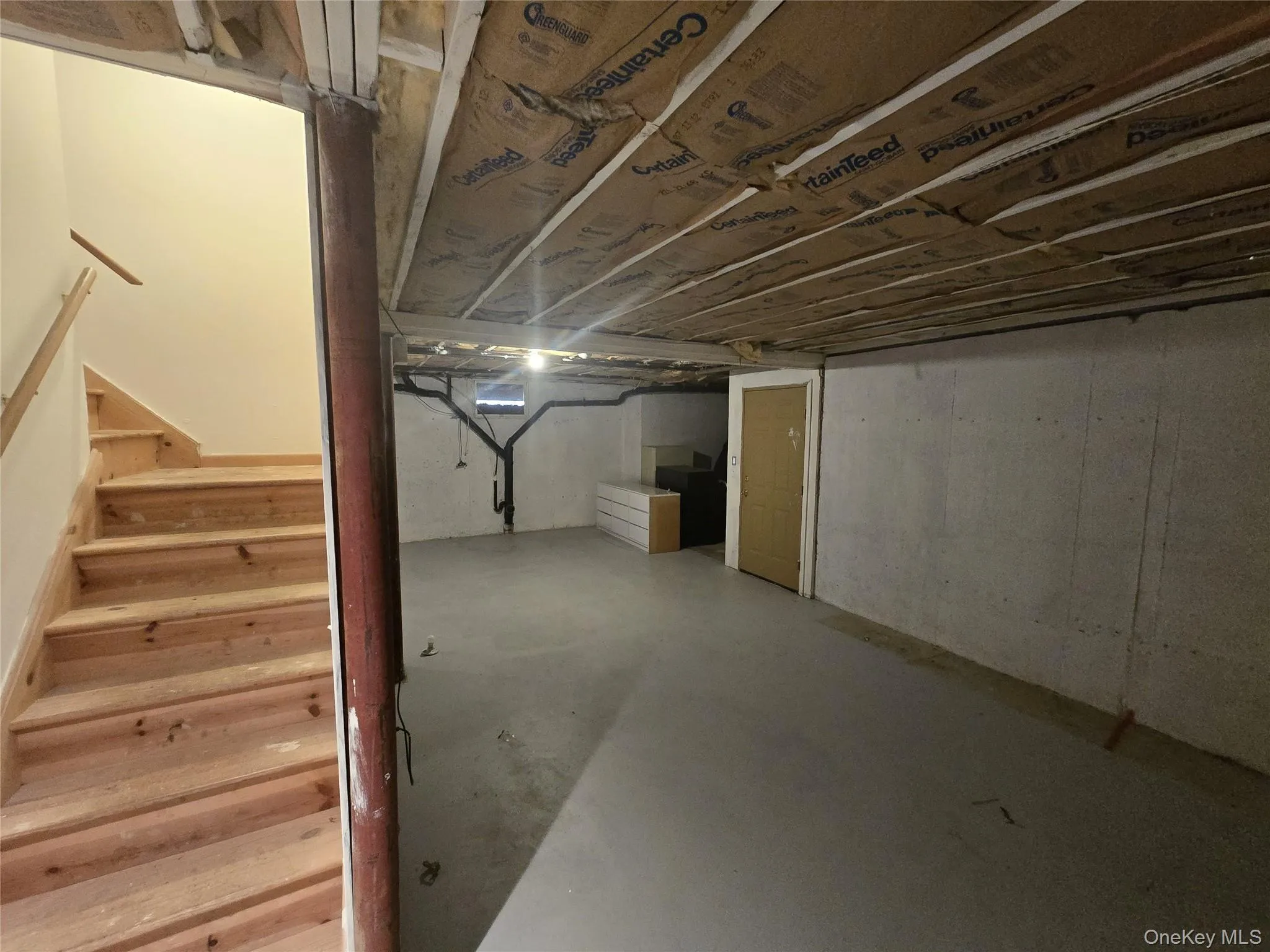 Unfinished below grade area featuring stairs Unfinished below grade area featuring stairs