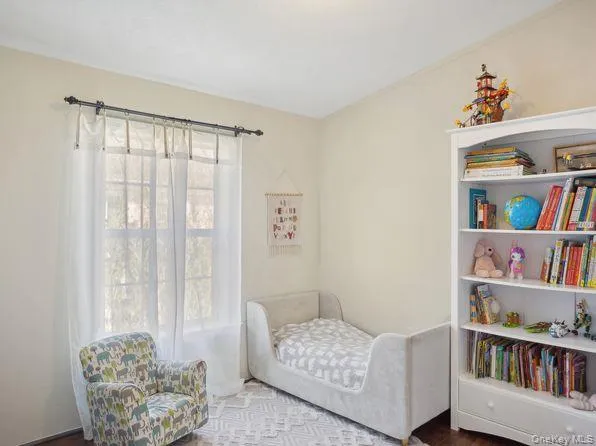 Bedroom with dark wood finished floors and a nursery area Bedroom with dark wood finished floors and a nursery area