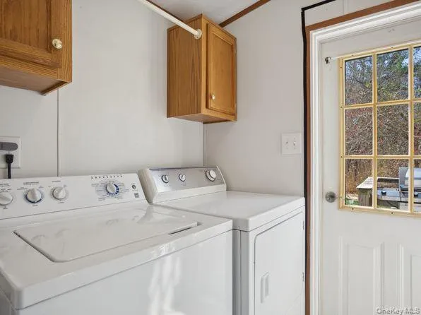 Laundry room featuring cabinet space, independent washer and dryer, and crown molding Laundry room featuring cabinet space, independent washer and dryer, and crown molding