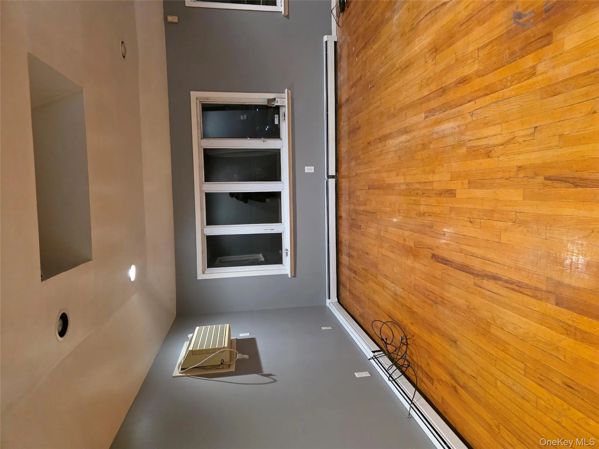 Empty room featuring baseboard heating, light wood finished floors, recessed lighting, and a raised ceiling Empty room featuring baseboard heating, light wood finished floors, recessed lighting, and a raised ceiling