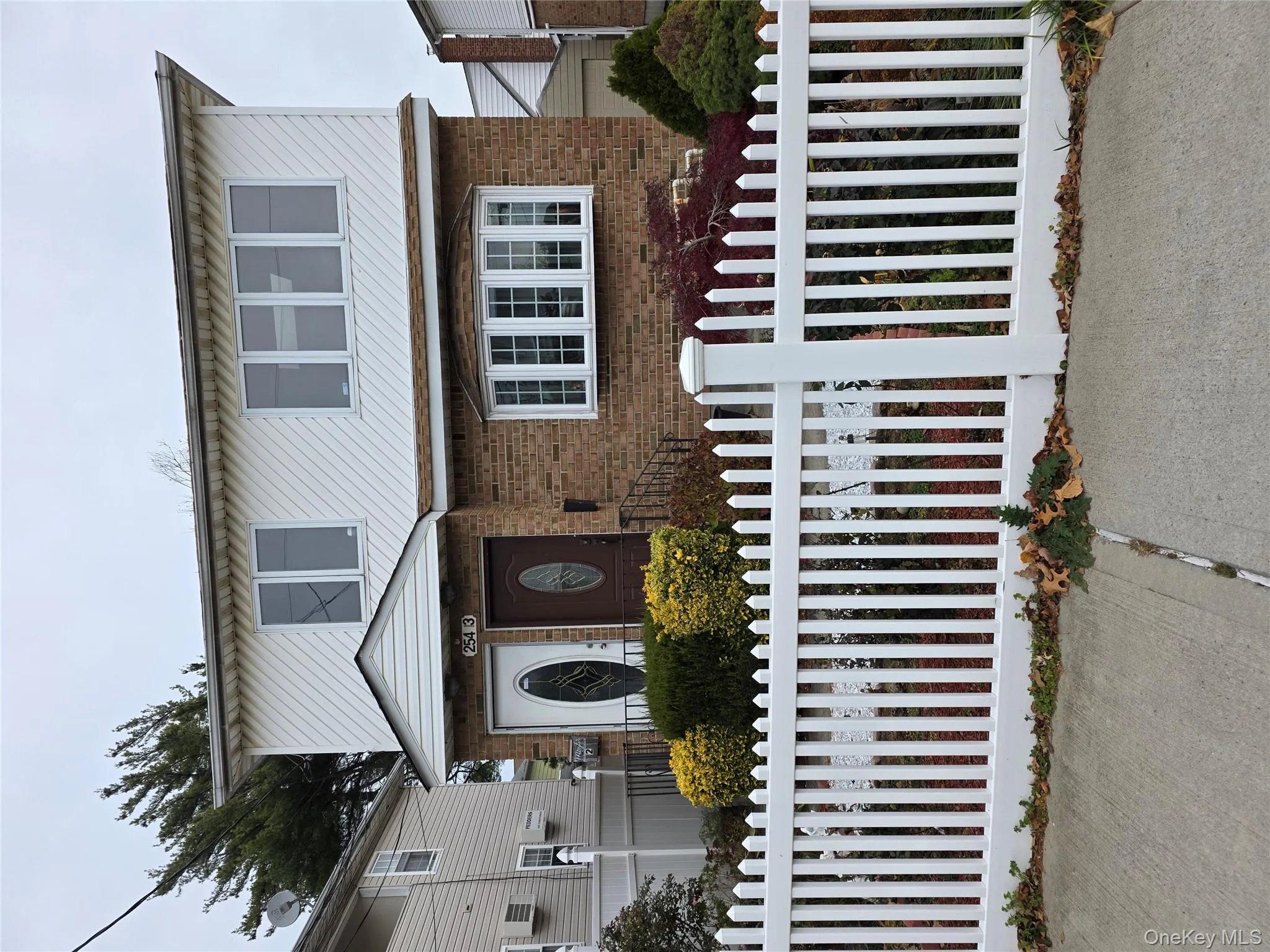 Traditional-style house with brick siding and a fenced front yard Traditional-style house with brick siding and a fenced front yard