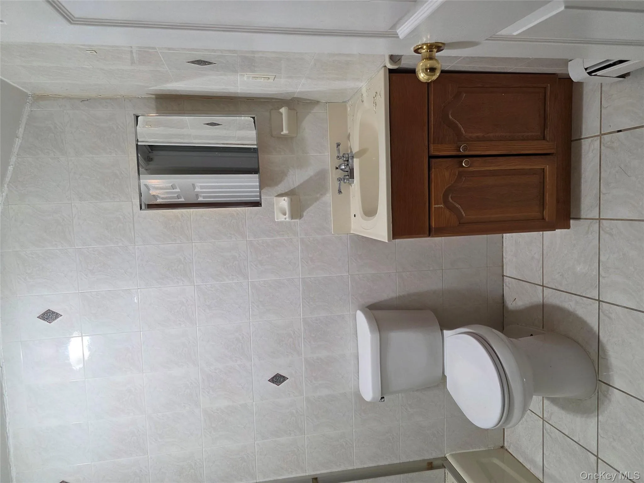 Bathroom with tile walls, vanity, light tile patterned floors, baseboard heating, and shower / bathtub combination Bathroom with tile walls, vanity, light tile patterned floors, baseboard heating, and shower / bathtub combination