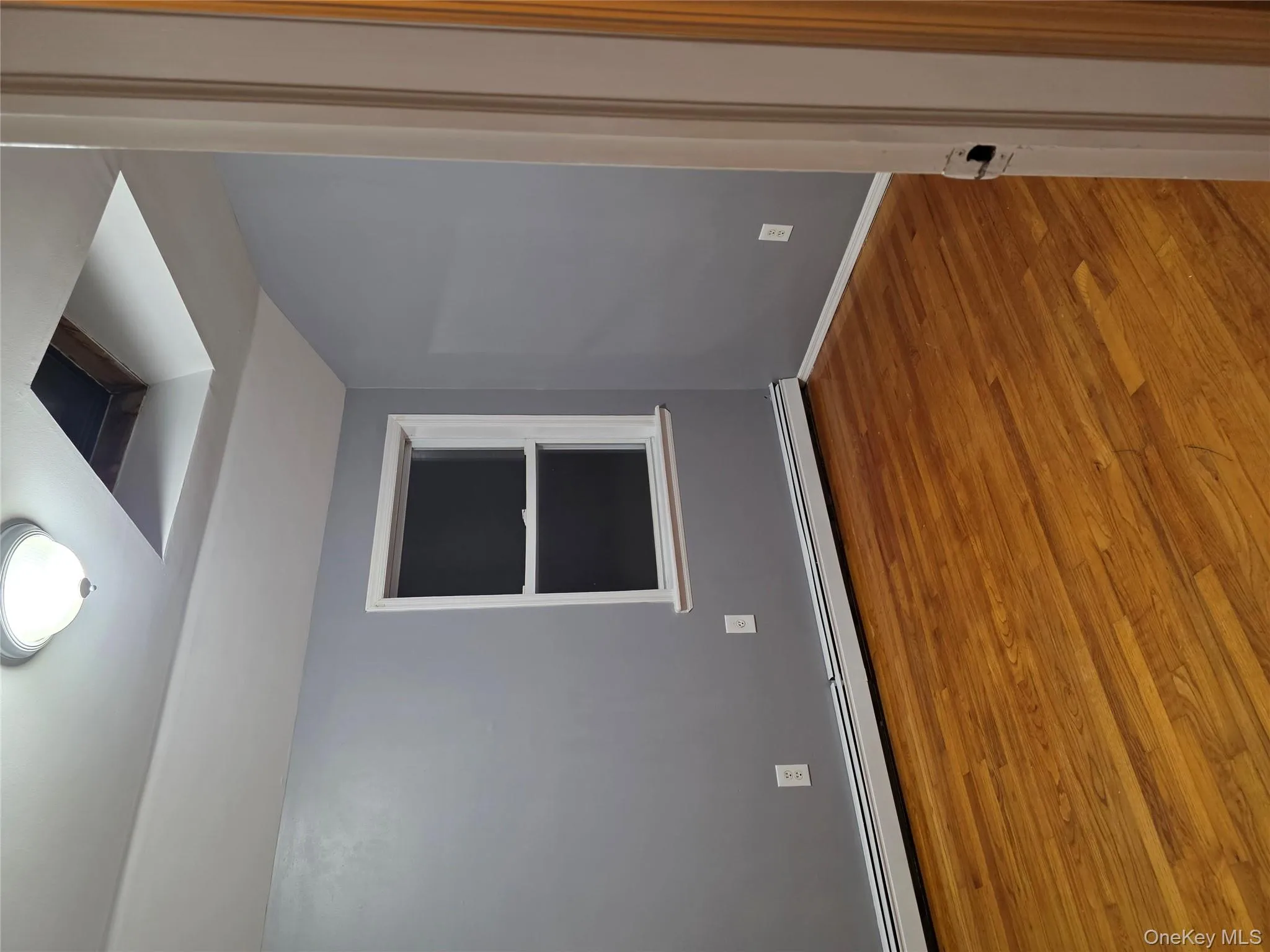 Empty room featuring a baseboard radiator, wood finished floors, and lofted ceiling Empty room featuring a baseboard radiator, wood finished floors, and lofted ceiling