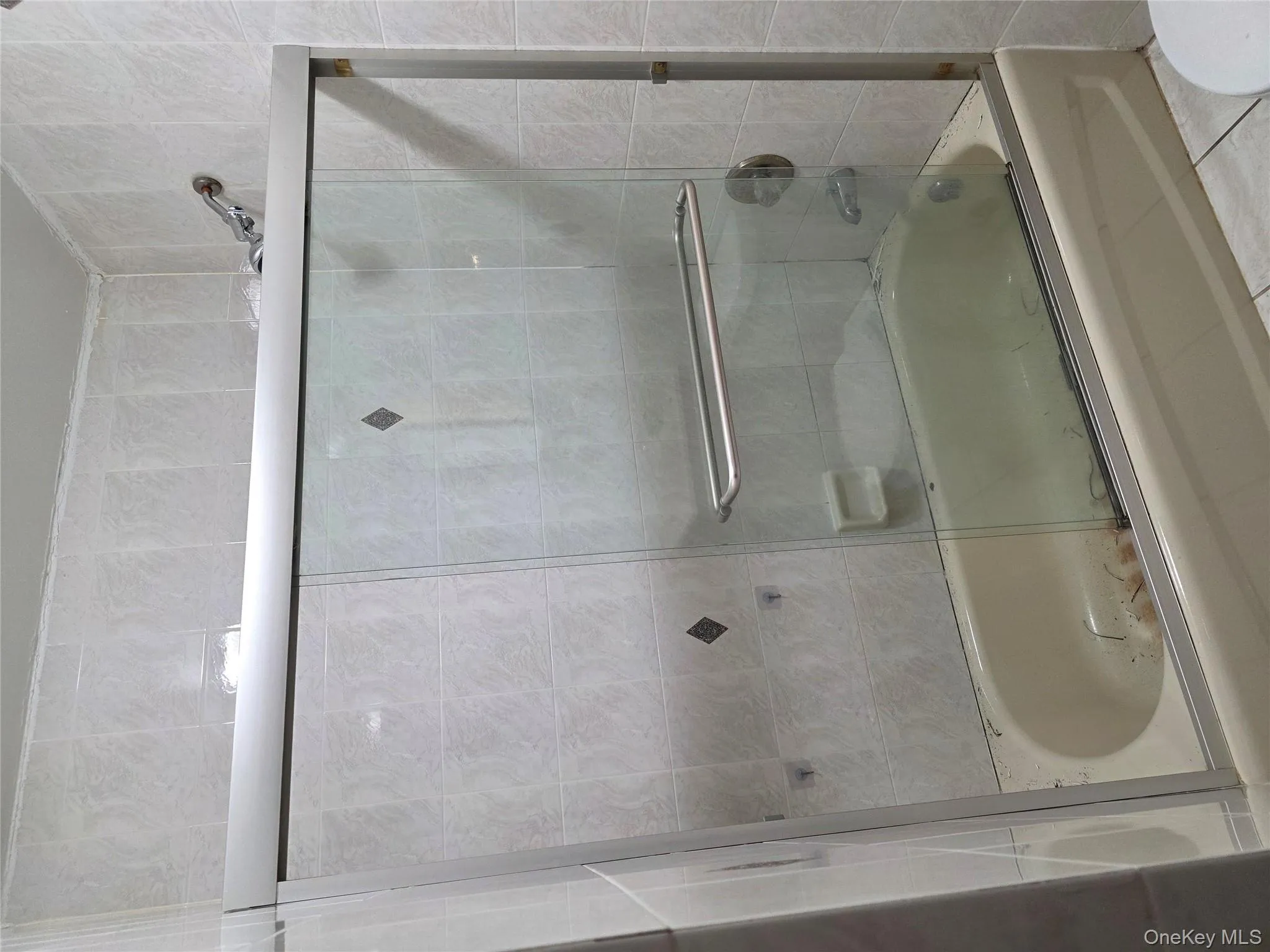 Full bath featuring combined bath / shower with glass door and toilet Full bath featuring combined bath / shower with glass door and toilet