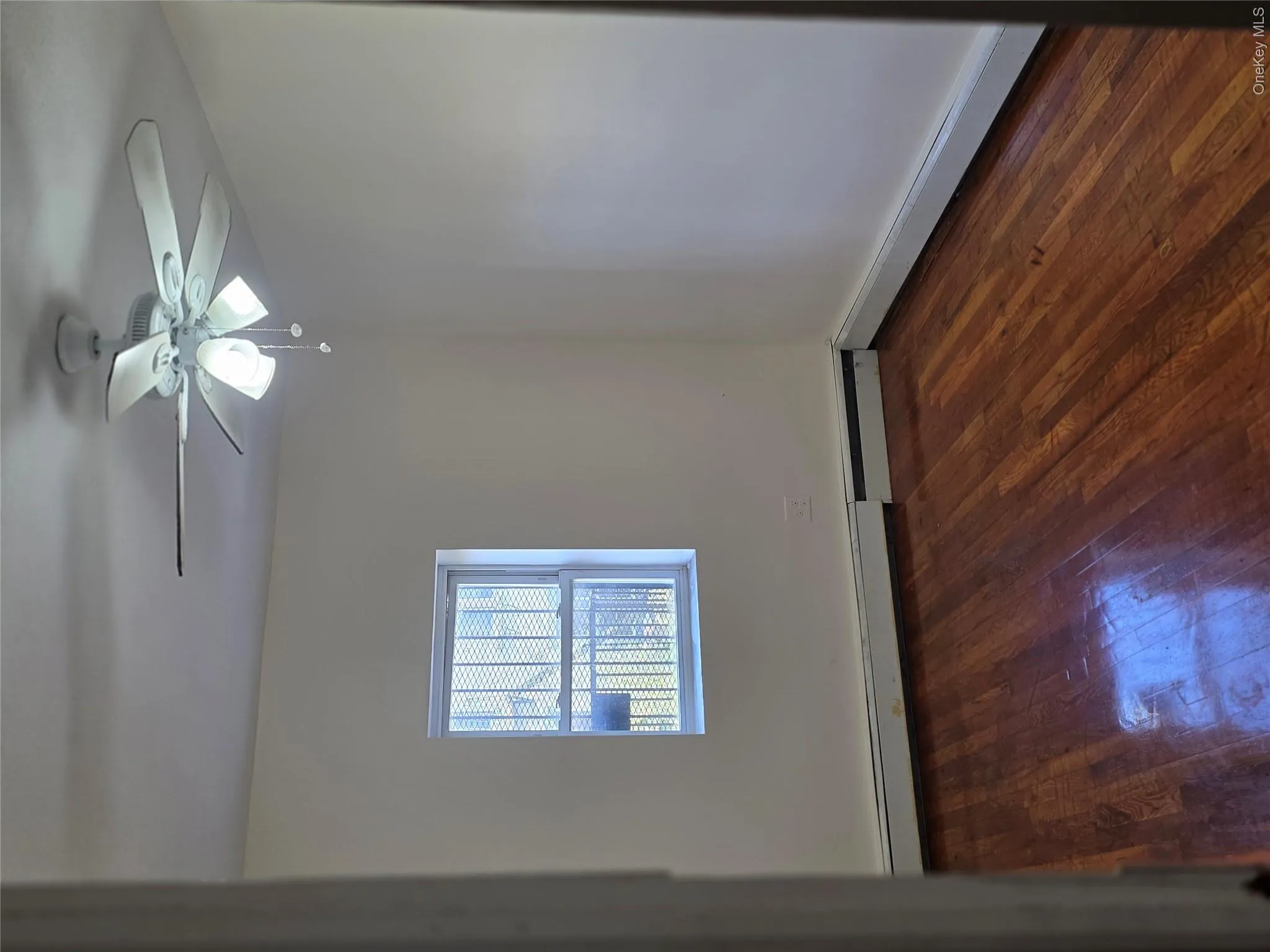 Unfurnished room featuring dark wood-style floors, ceiling fan, baseboard heating, and a baseboard radiator Unfurnished room featuring dark wood-style floors, ceiling fan, baseboard heating, and a baseboard radiator