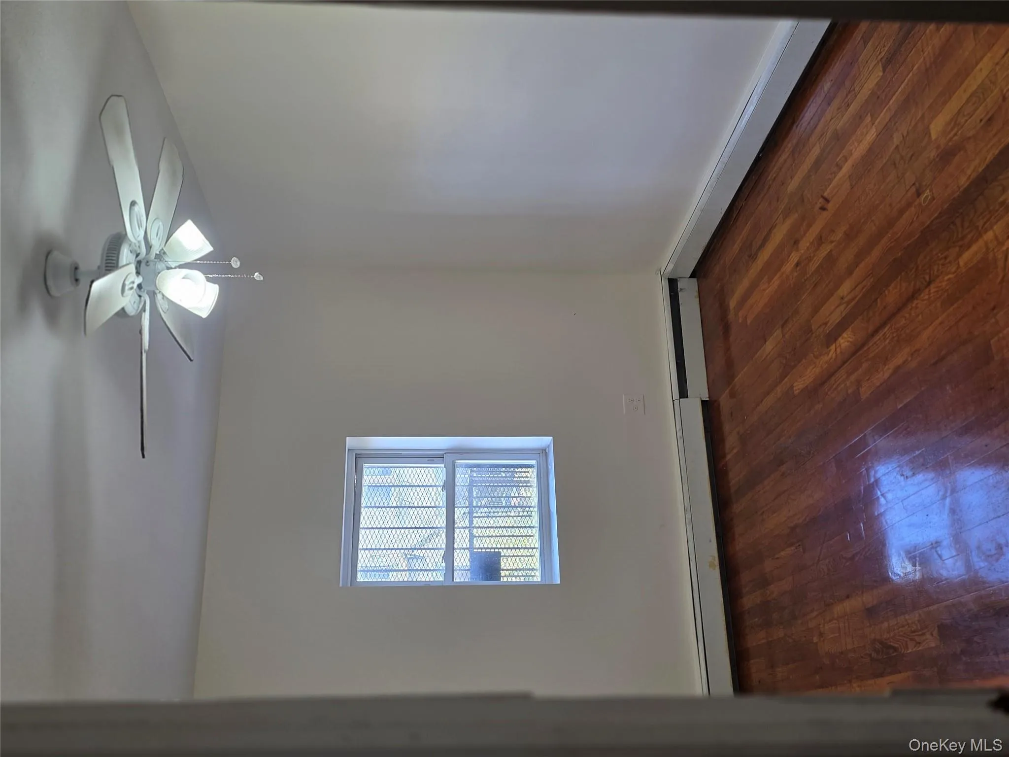 Unfurnished room featuring dark wood-style floors, ceiling fan, baseboard heating, and a baseboard radiator Unfurnished room featuring dark wood-style floors, ceiling fan, baseboard heating, and a baseboard radiator