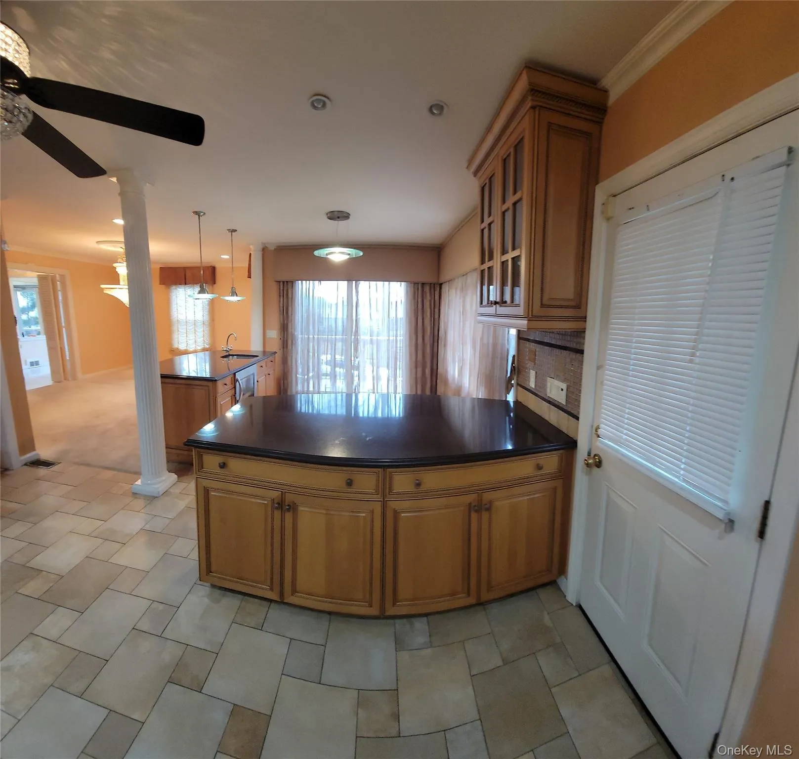 Kitchen featuring a peninsula, brown cabinetry, glass insert cabinets, decorative backsplash, and stainless steel dishwasher Kitchen featuring a peninsula, brown cabinetry, glass insert cabinets, decorative backsplash, and stainless steel dishwasher