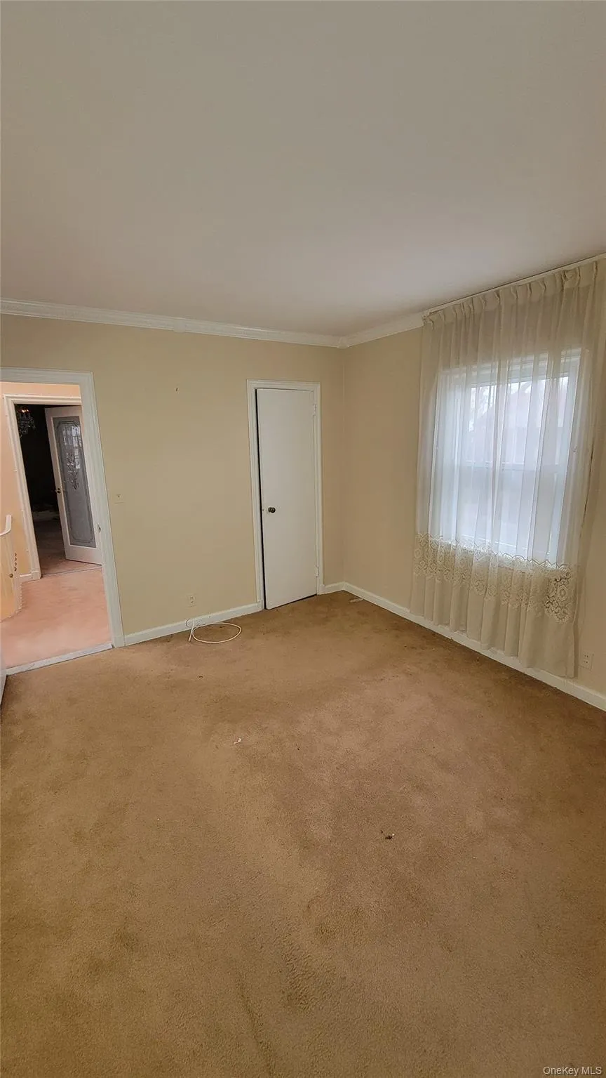 Spare room with ornamental molding and light carpet Spare room with ornamental molding and light carpet