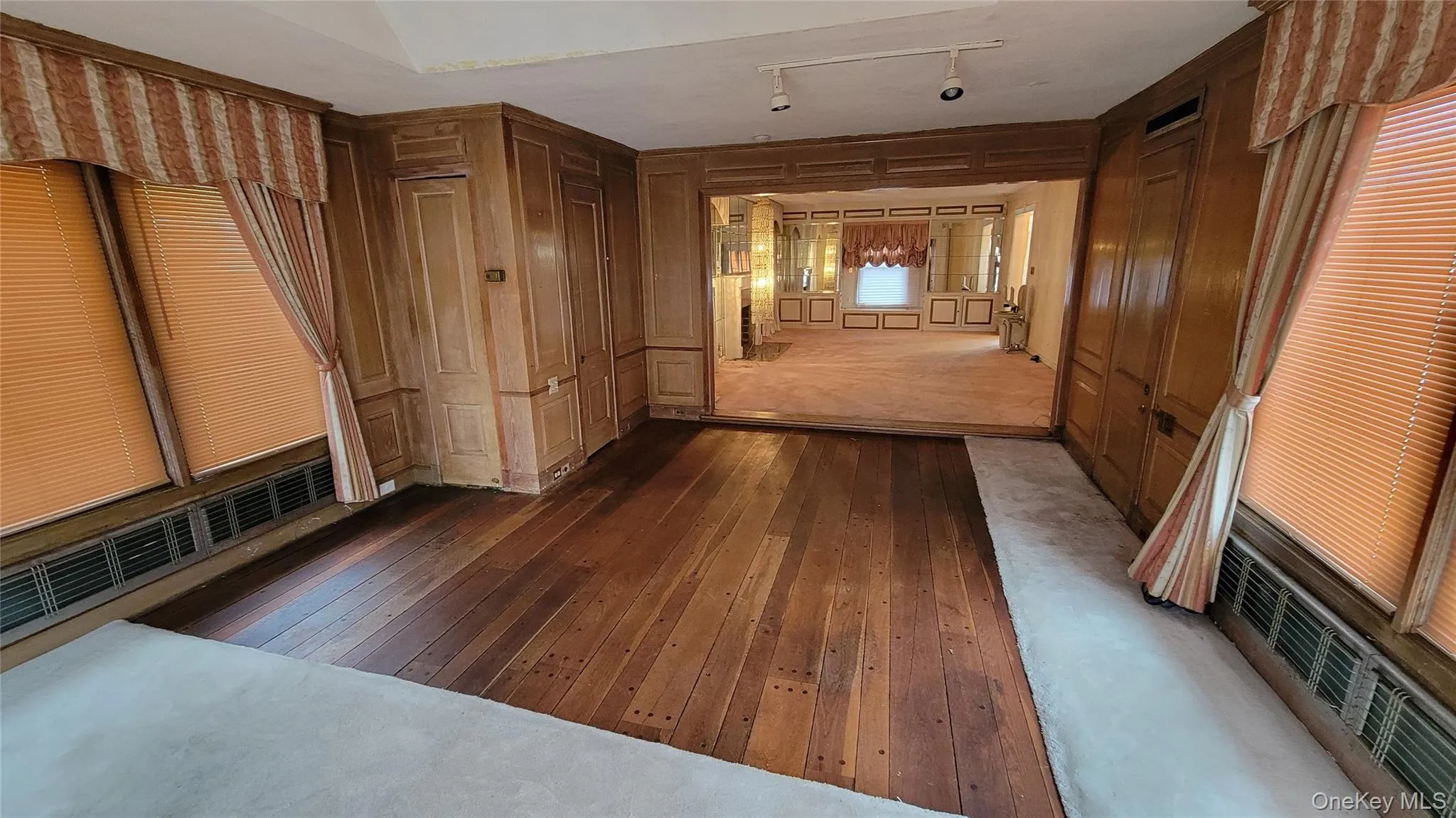 Corridor with dark wood finished floors, wooden walls, and a decorative wall Corridor with dark wood finished floors, wooden walls, and a decorative wall