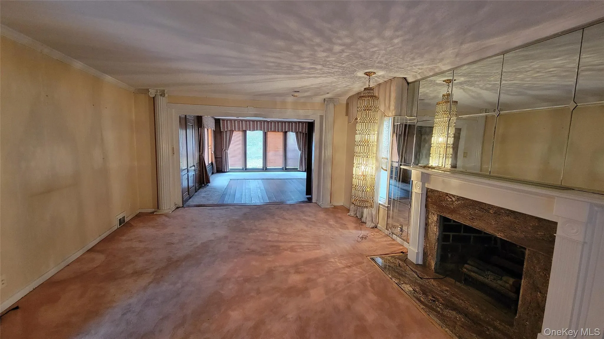 Unfurnished living room with a high end fireplace, carpet, and crown molding Unfurnished living room with a high end fireplace, carpet, and crown molding