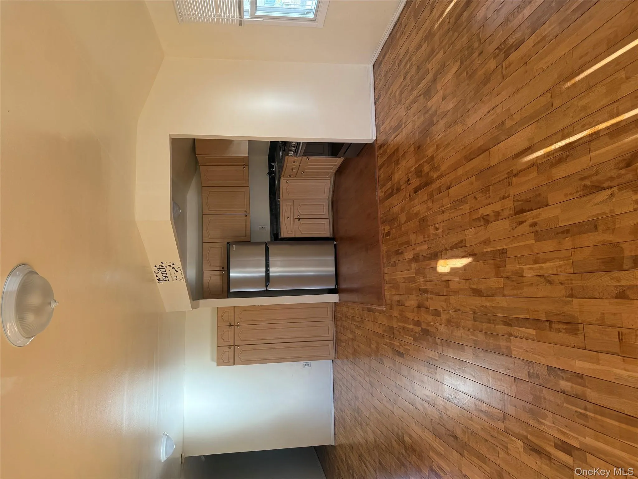 Kitchen featuring dark countertops, stainless steel refrigerator, dark wood-style flooring, and open floor plan Kitchen featuring dark countertops, stainless steel refrigerator, dark wood-style flooring, and open floor plan