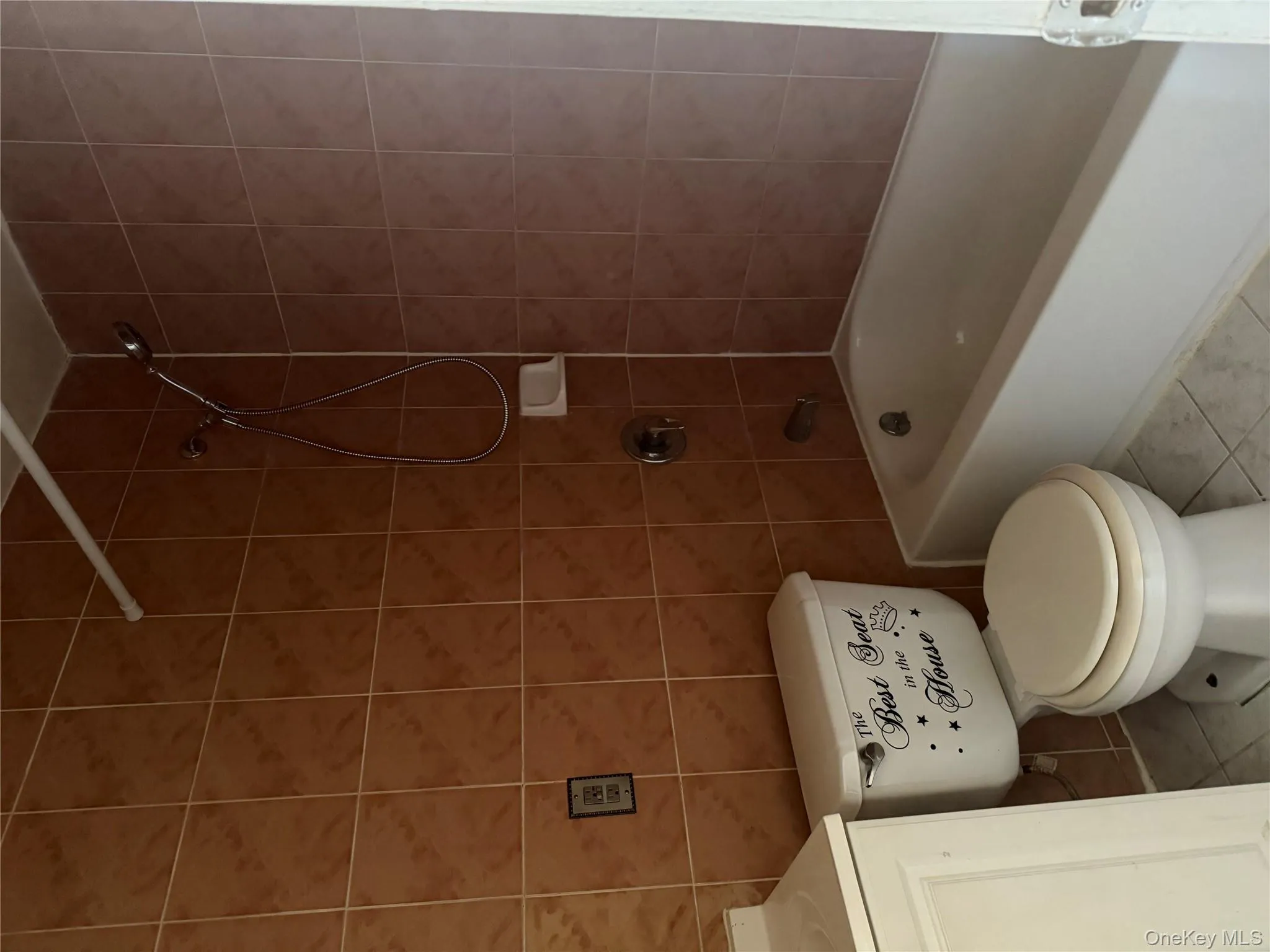 Bathroom featuring bathtub / shower combination, light tile patterned flooring, tile walls, and vanity Bathroom featuring bathtub / shower combination, light tile patterned flooring, tile walls, and vanity