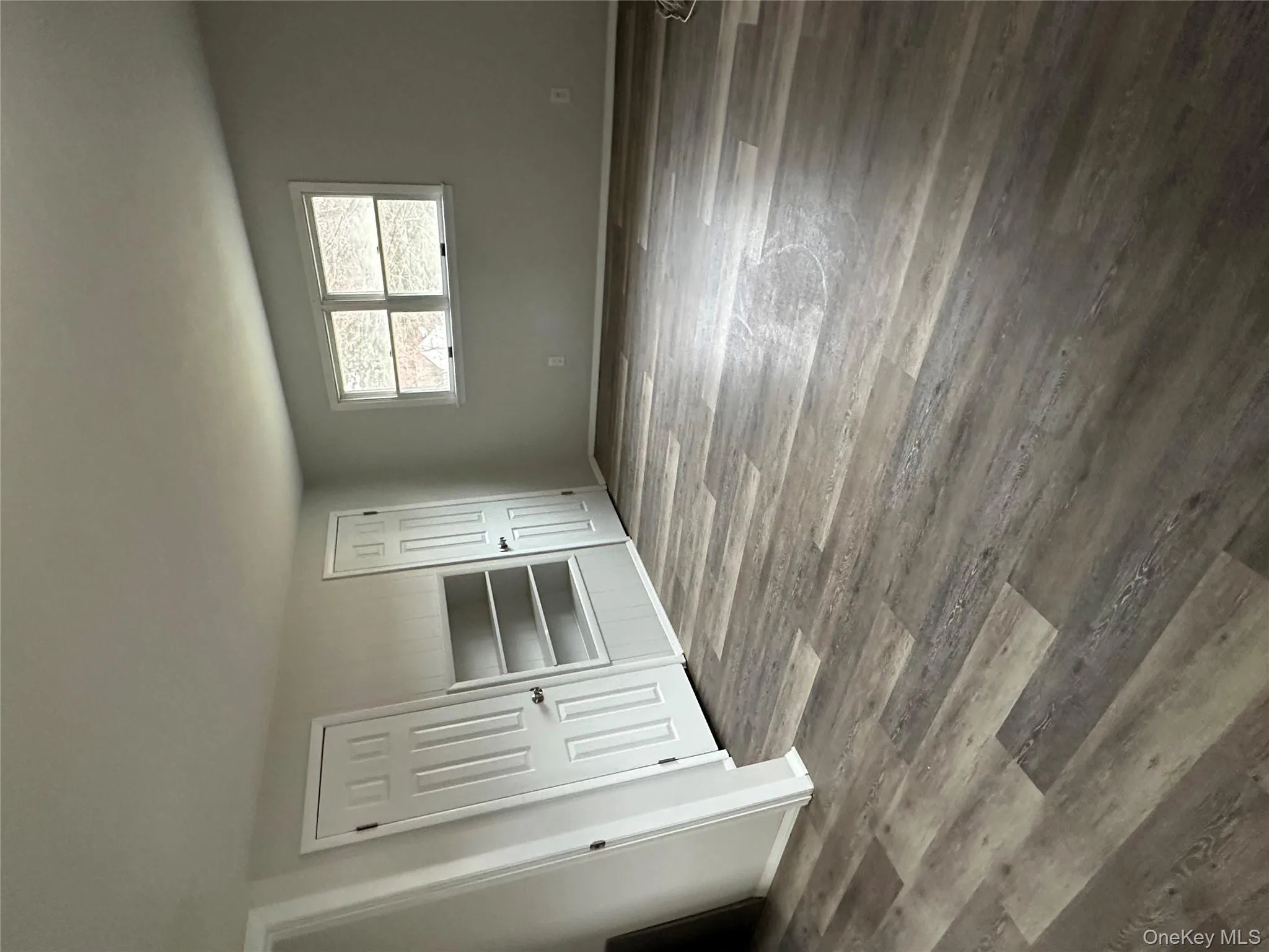 Unfurnished bedroom with dark wood-style flooring and multiple closets Unfurnished bedroom with dark wood-style flooring and multiple closets