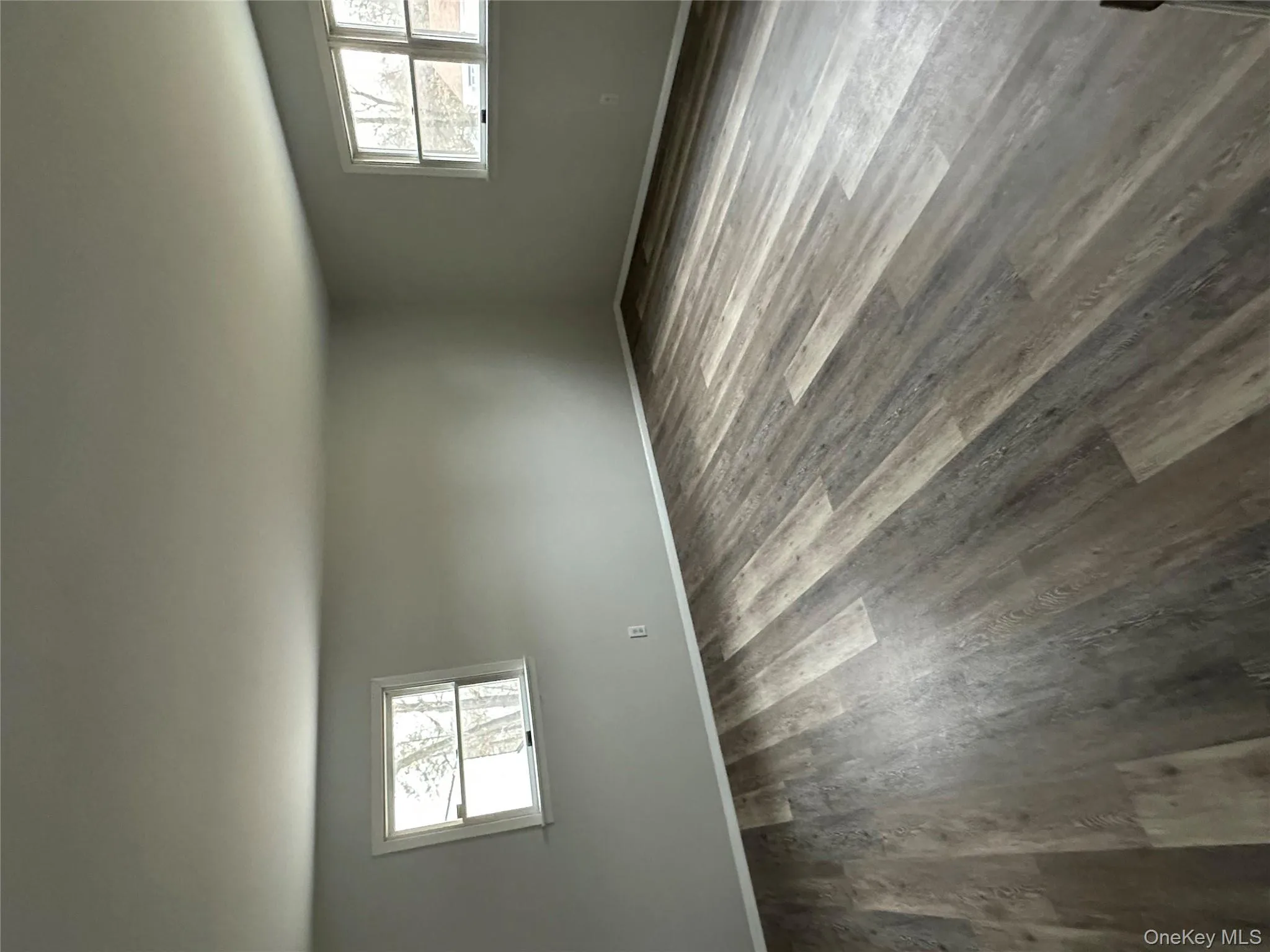 Empty room featuring plenty of natural light and dark wood-style flooring Empty room featuring plenty of natural light and dark wood-style flooring