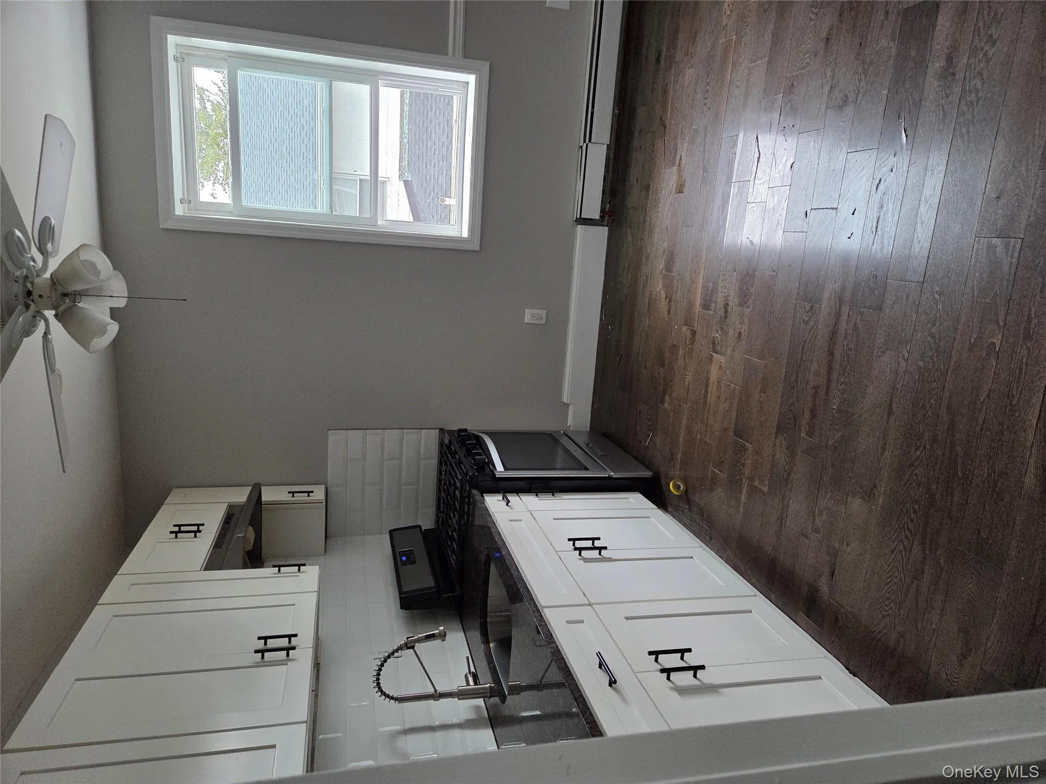 Kitchen with stainless steel range oven, dark stone counters, white cabinetry, and dark wood-style flooring Kitchen with stainless steel range oven, dark stone counters, white cabinetry, and dark wood-style flooring