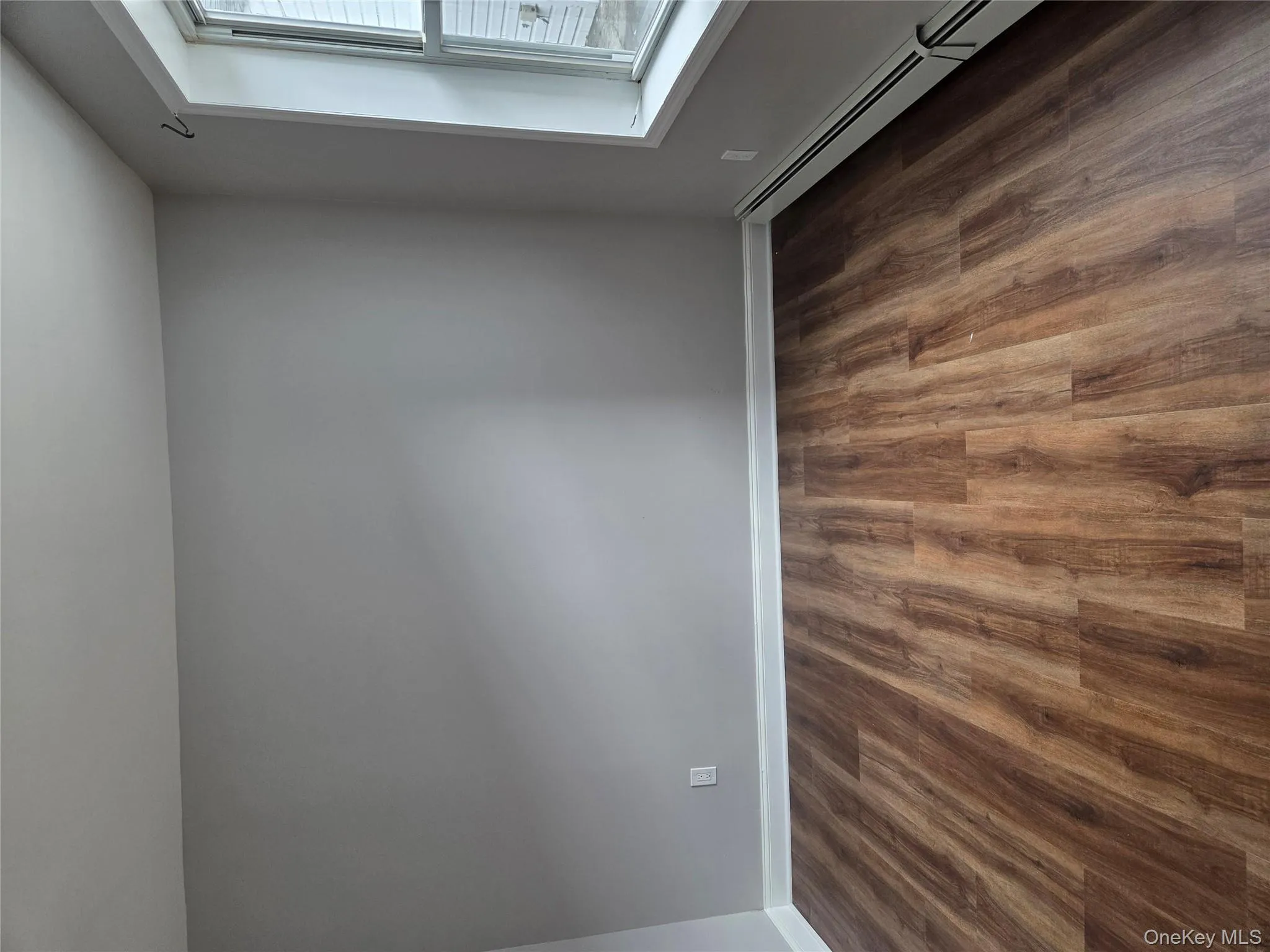 Empty room with baseboard heating and dark wood-style flooring Empty room with baseboard heating and dark wood-style flooring