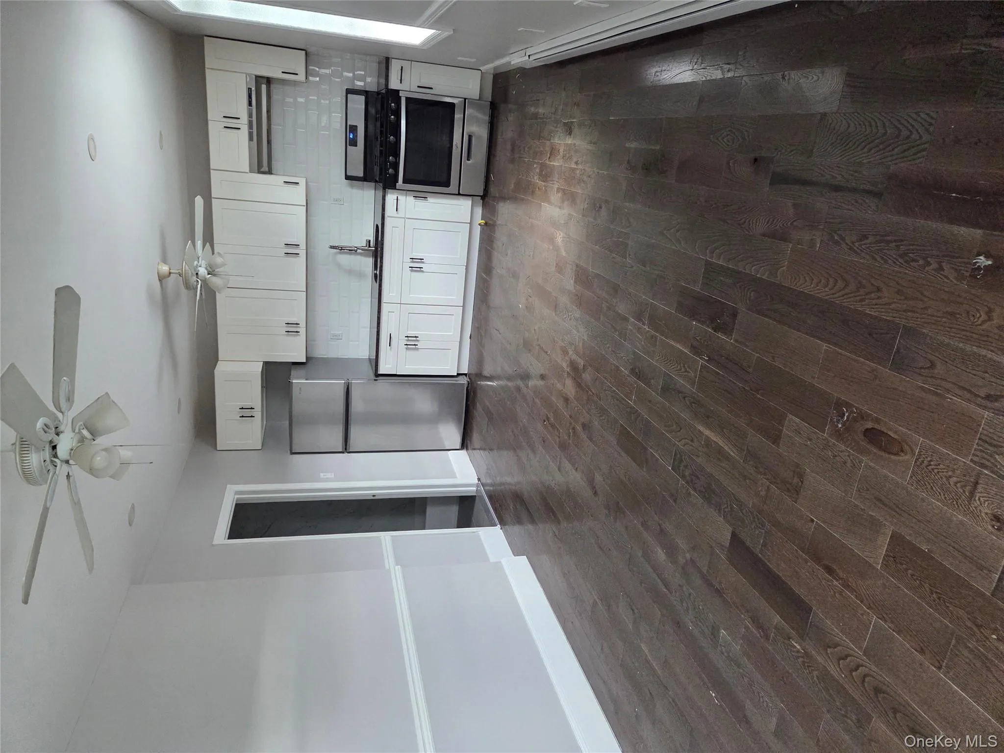 Kitchen featuring backsplash, white cabinets, stove, refrigerator, and dark wood finished floors Kitchen featuring backsplash, white cabinets, stove, refrigerator, and dark wood finished floors