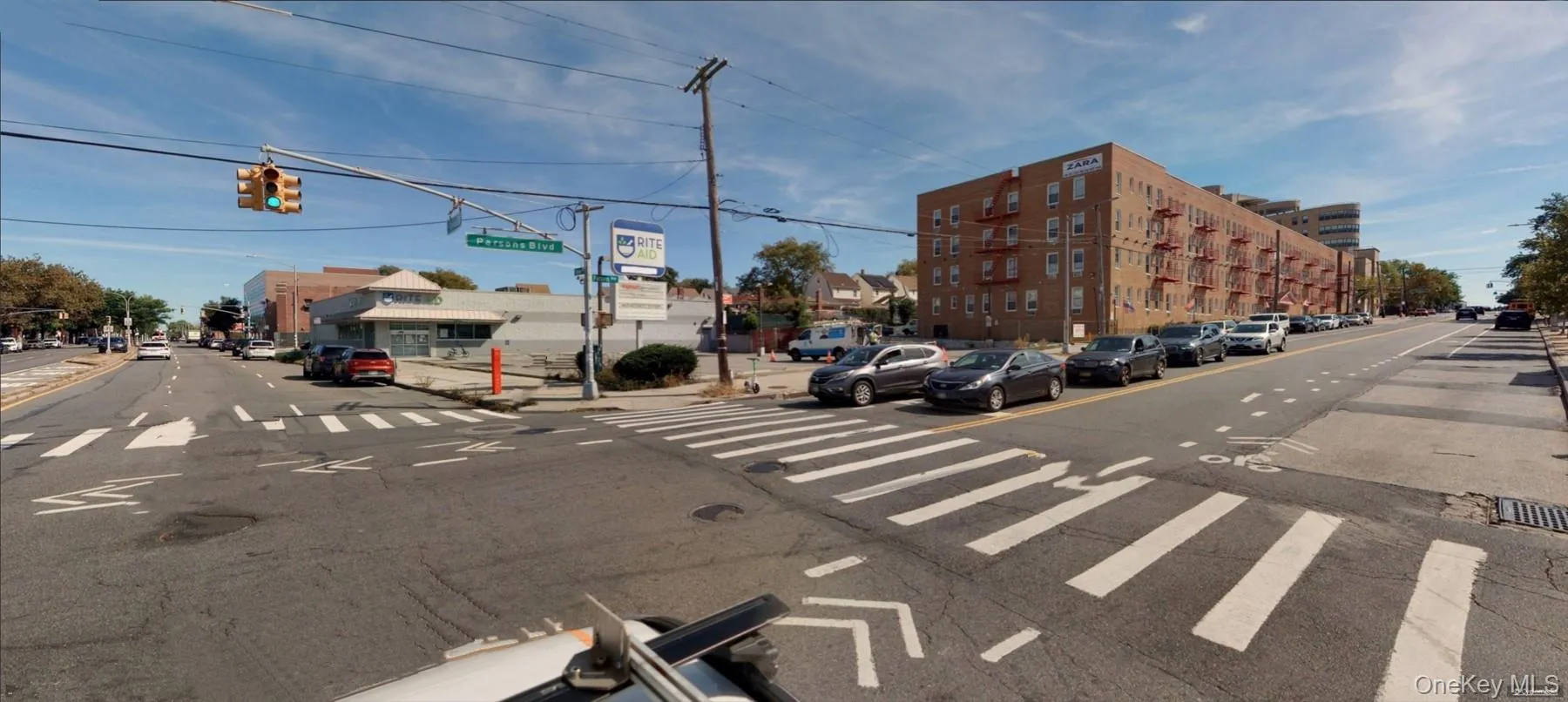 View of asphalt street featuring traffic lights, sidewalks, curbs, and street lights View of asphalt street featuring traffic lights, sidewalks, curbs, and street lights