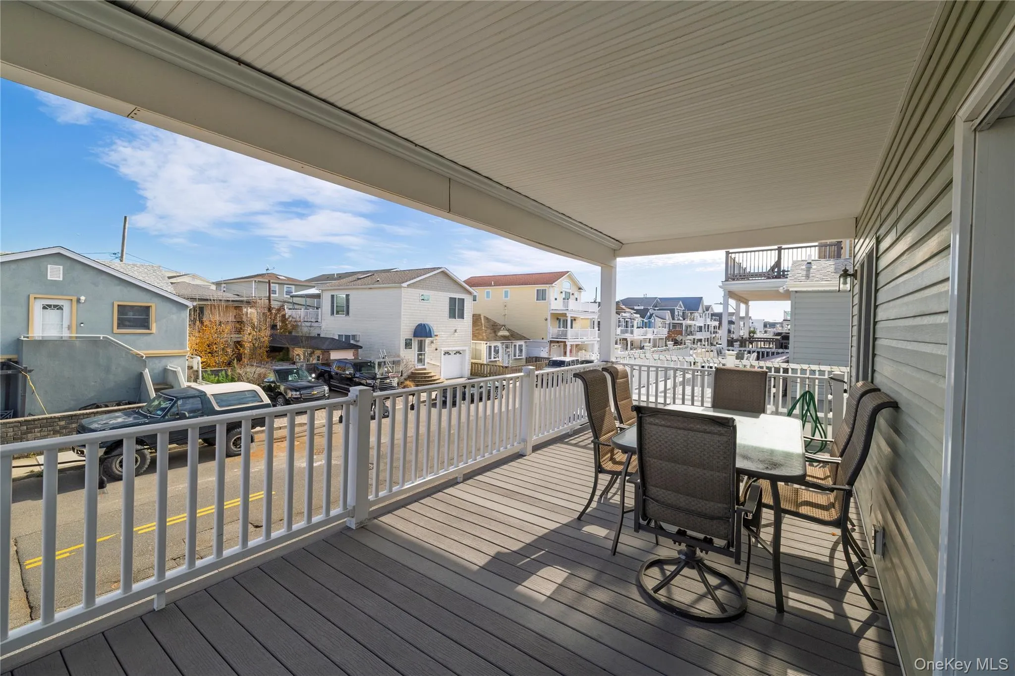 Wooden terrace featuring outdoor dining space and a residential view Wooden terrace featuring outdoor dining space and a residential view