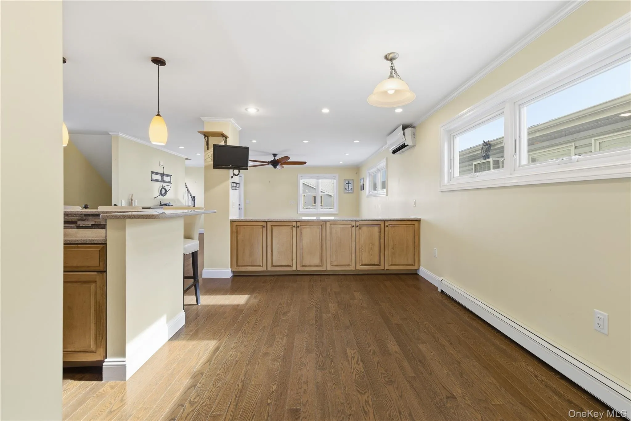 Kitchen featuring a baseboard heating unit, pendant lighting, ornamental molding, dark wood-style floors, and recessed lighting Kitchen featuring a baseboard heating unit, pendant lighting, ornamental molding, dark wood-style floors, and recessed lighting