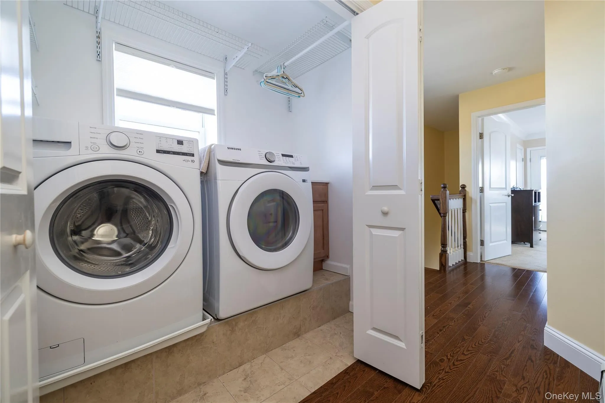 Laundry area featuring wood finished floors and washing machine and dryer Laundry area featuring wood finished floors and washing machine and dryer