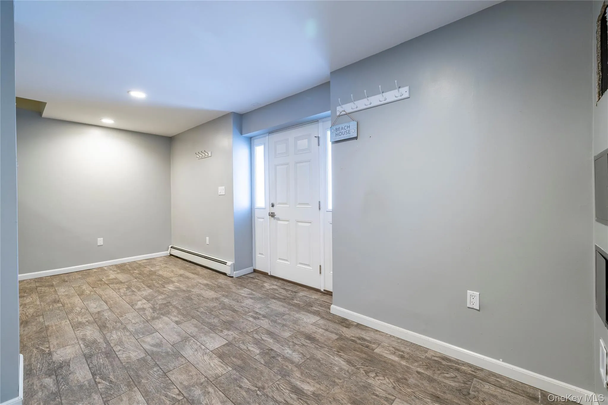 Below grade area featuring wood finished floors, baseboard heating, and recessed lighting Below grade area featuring wood finished floors, baseboard heating, and recessed lighting