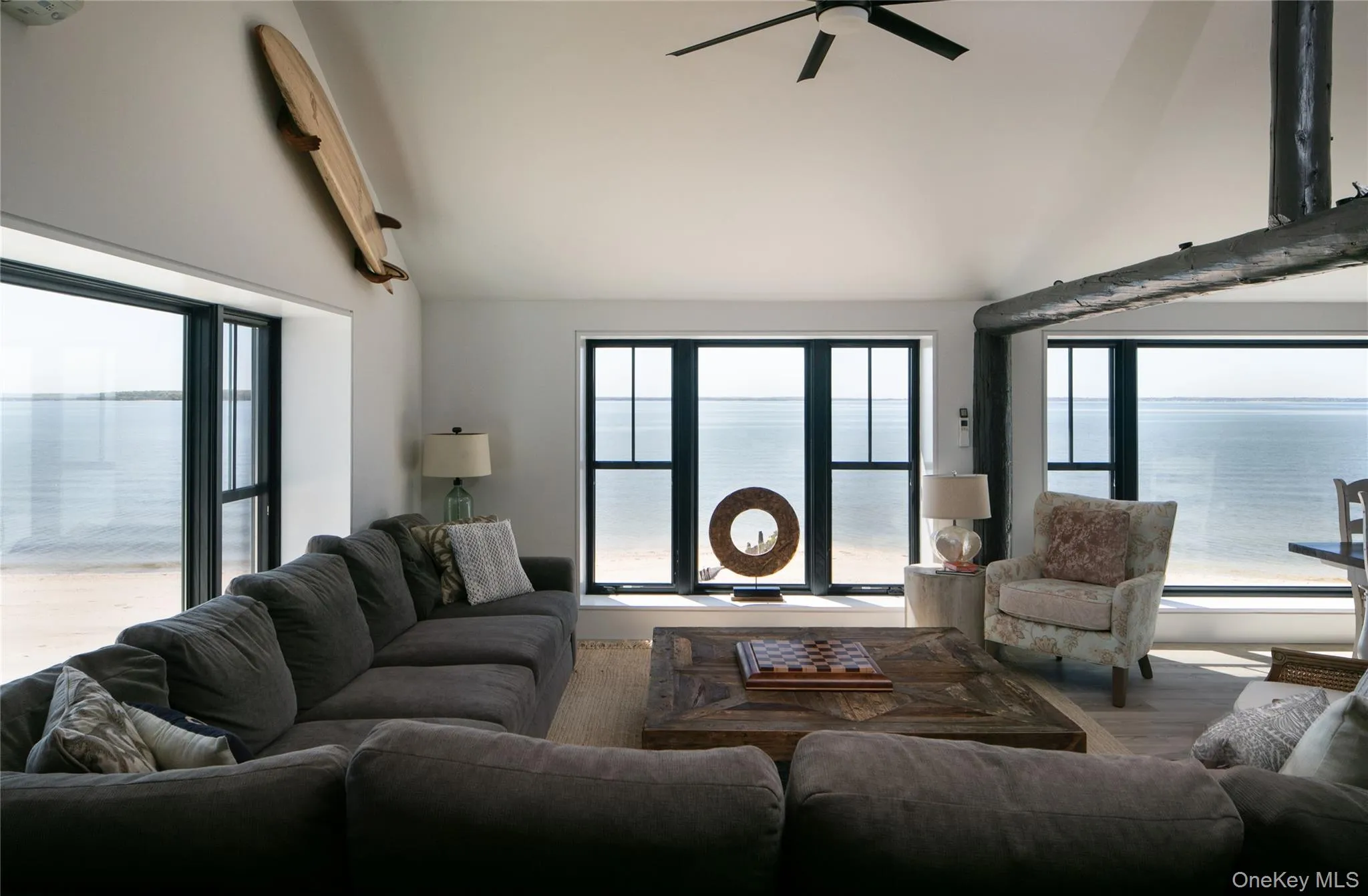 Living room featuring a water view, lofted ceiling, and a ceiling fan Living room featuring a water view, lofted ceiling, and a ceiling fan